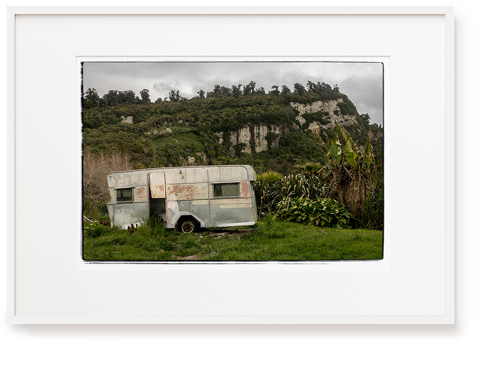 Photograph by Erica Leather of old caravan with cliffs behind west coat