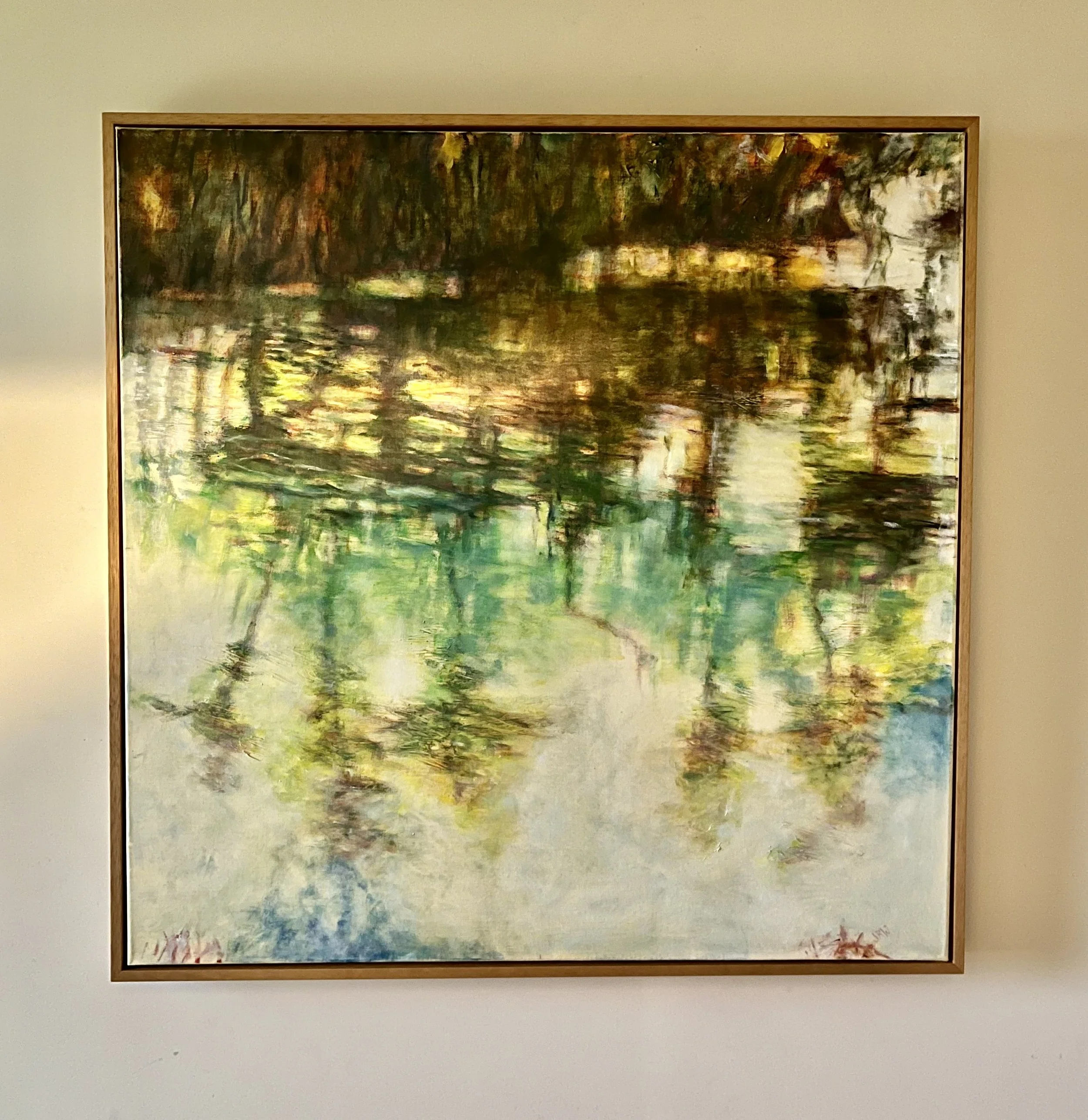 An impressionist style landscape painting depicting trees by a body of water, with reflections on the surface, using vibrant, expressive brushstrokes. Stretched canvas with wooden tray frame. 