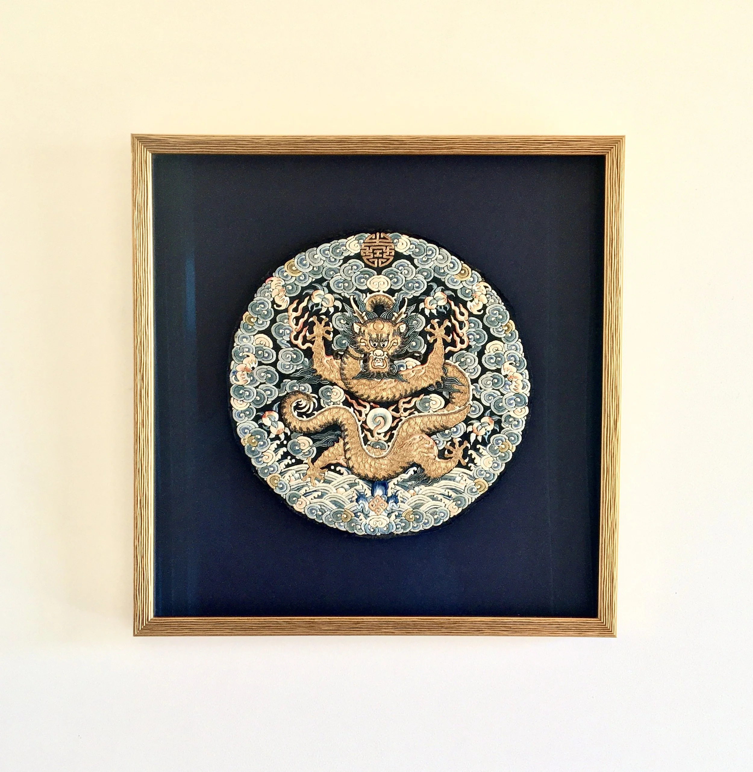 Vintage kimono framed with non-reflective glass, gold frame and a dark blue background. 