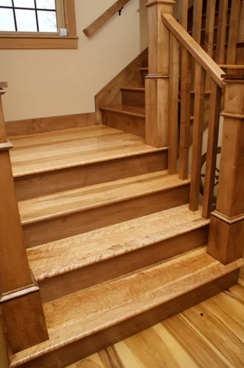 Wooden staircase with a newel post and railing inside a house