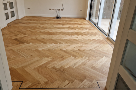 Empty room with hardwood flooring and large glass sliding doors.