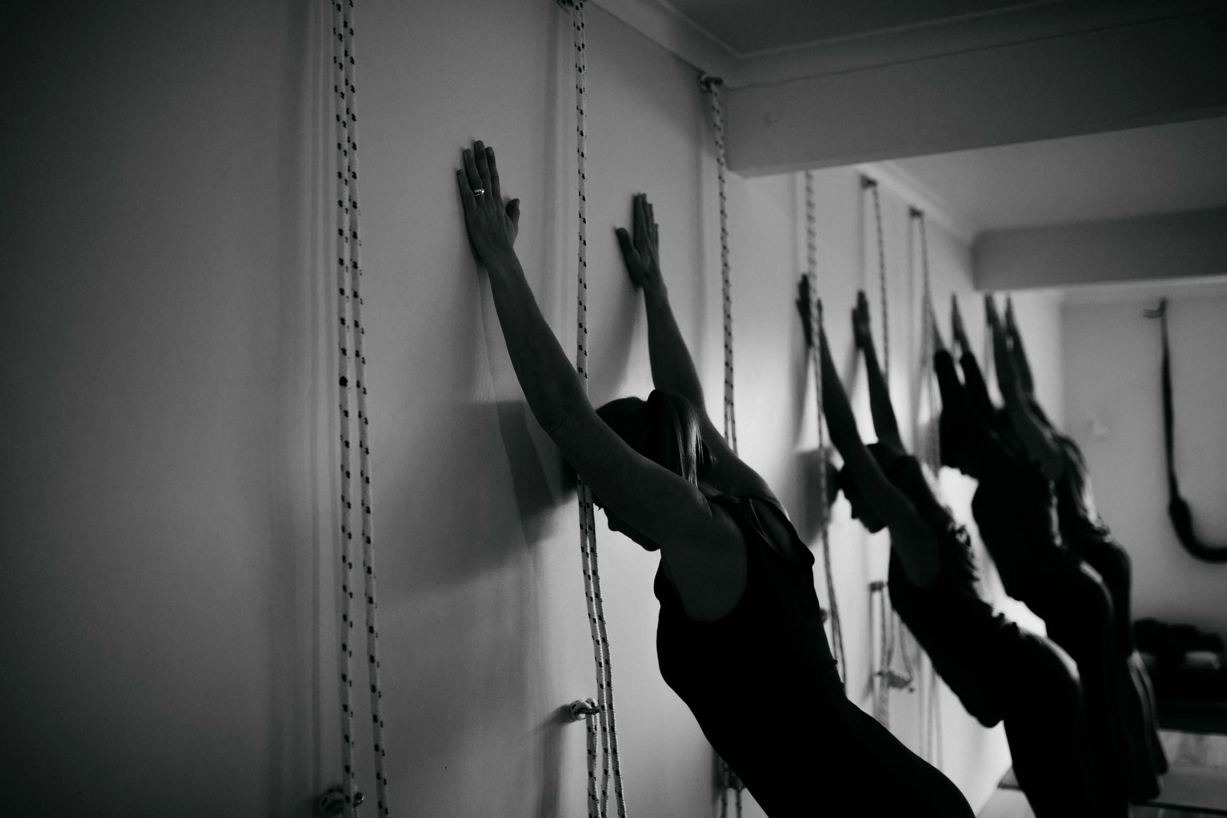Students practising Iyengar Yoga using wall ropes at Yoga Whitianga