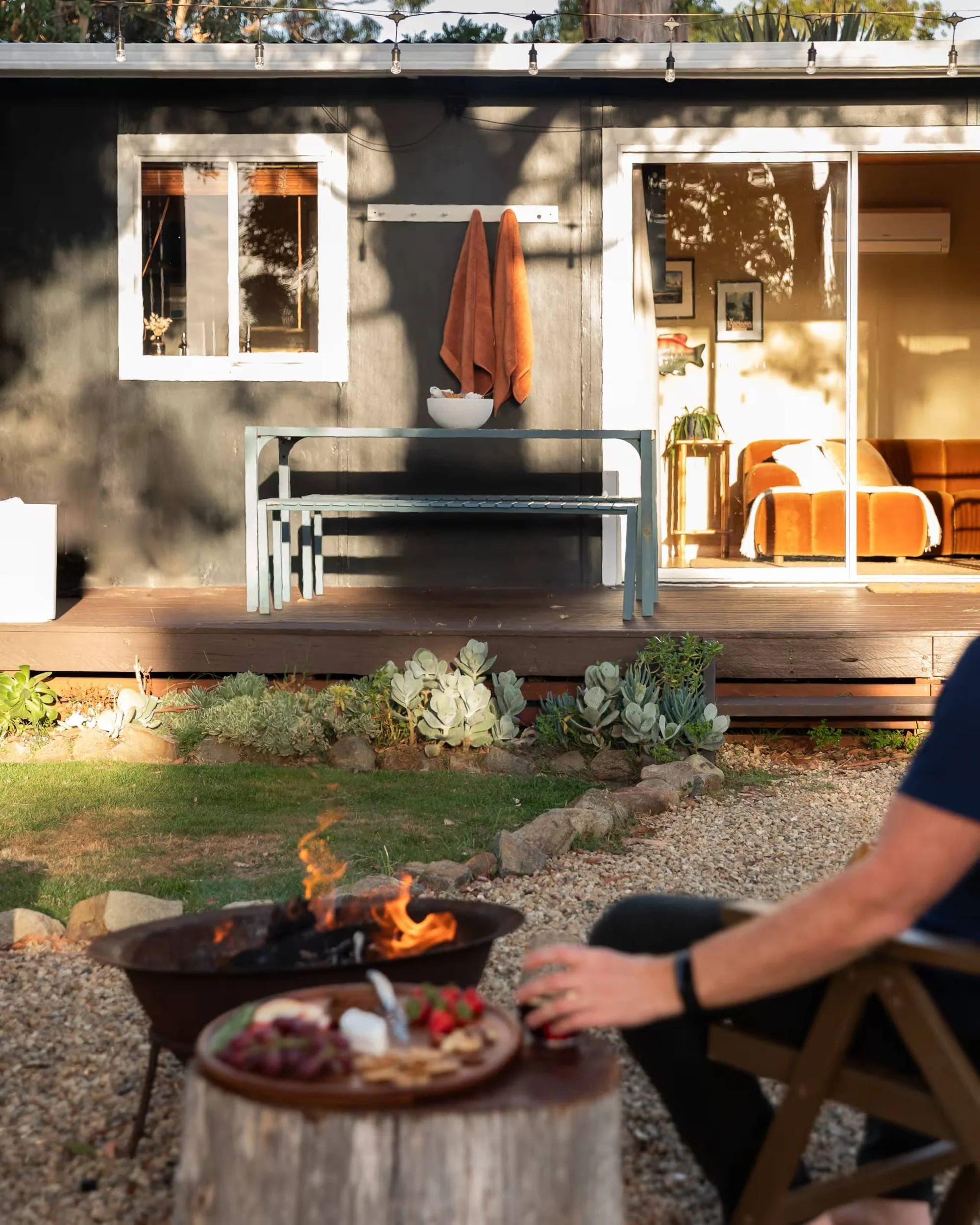 Guest by the fire pit, looking back to the glass doors and living room