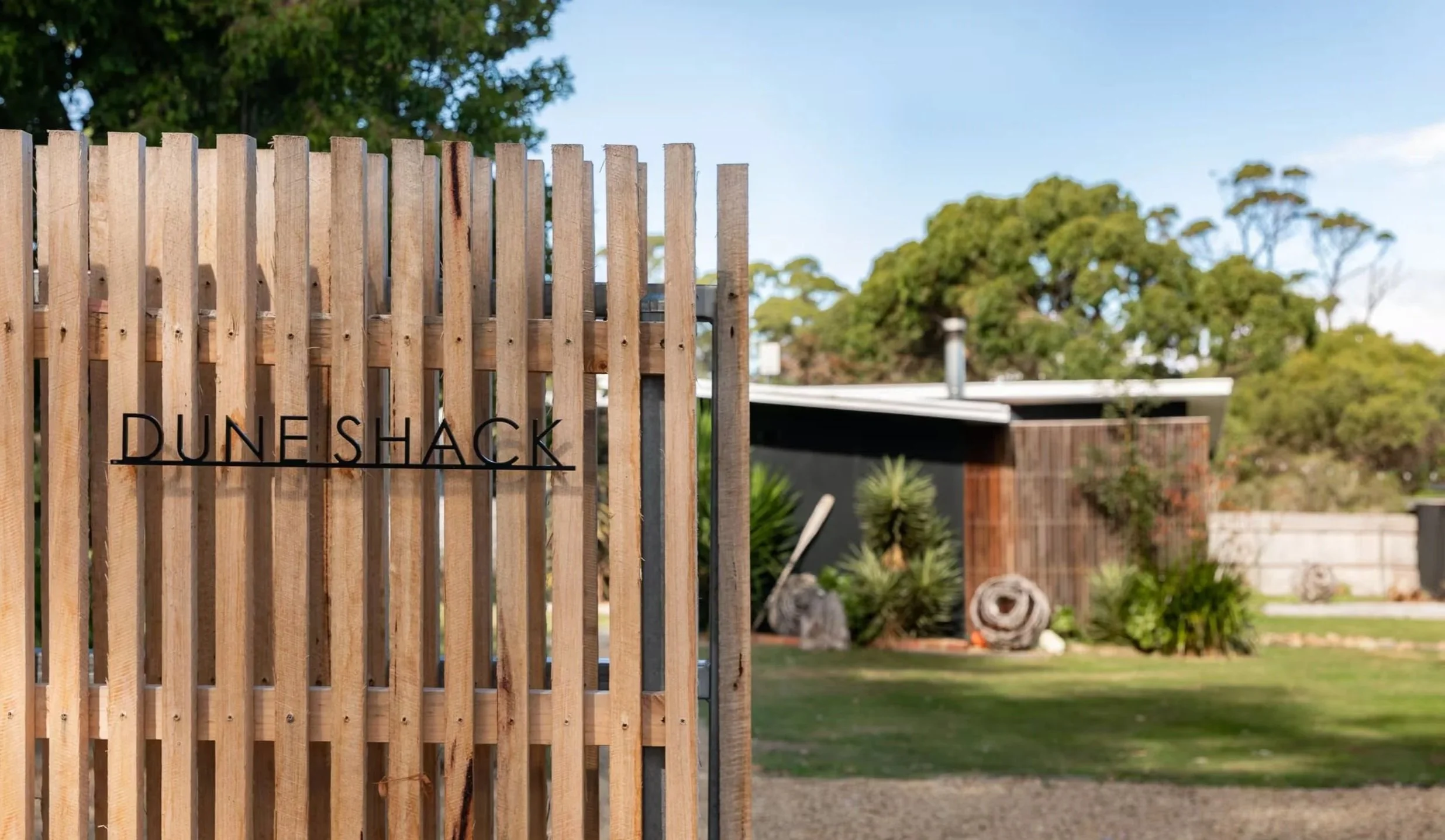 Timber fence and Dune Shack sign at the entrance to the property
