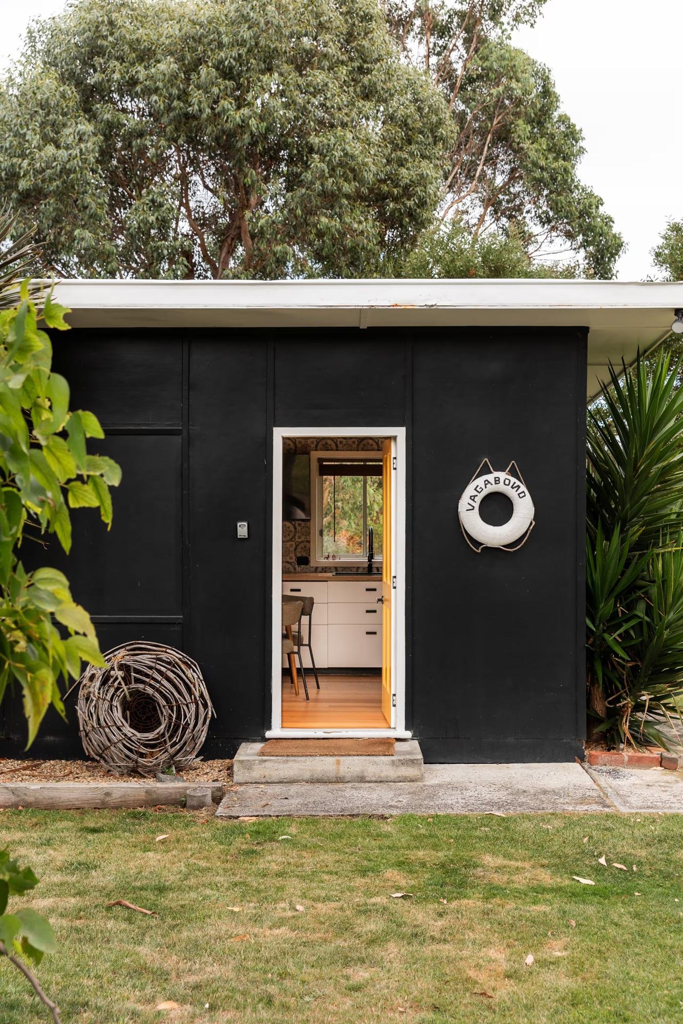 Open door into the Dune Shack kitchen, with a vintage lifebuoy on the exterior wall