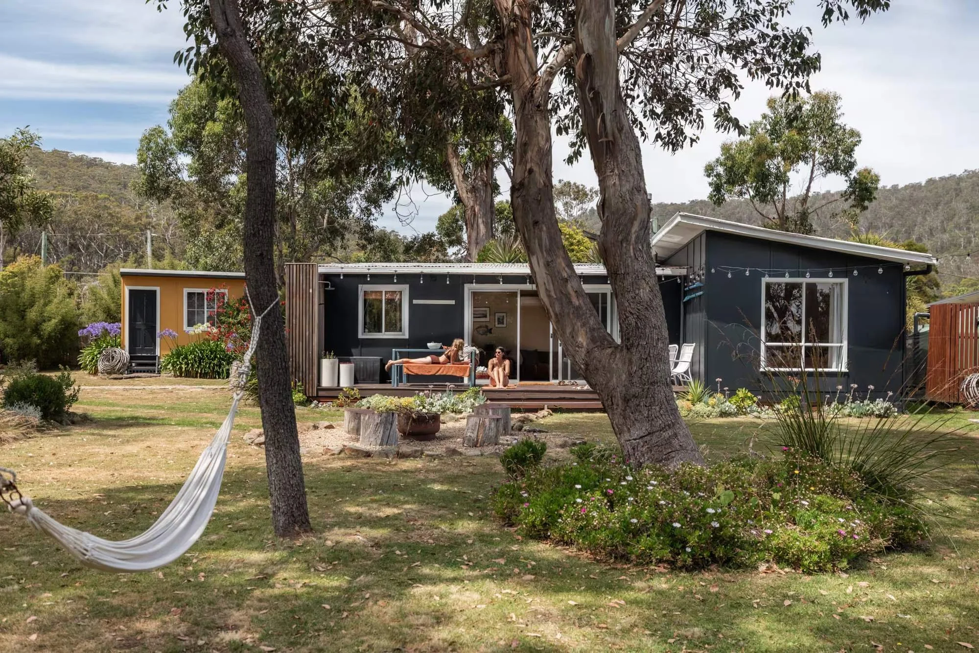 Guests on the patio beside the hammock in Dune Shack's native garden