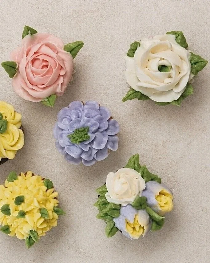 Assorted colorful flower-shaped pastries on a light background.