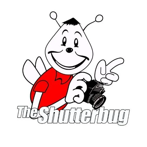 Cartoon character with antennae holding a camera, smiling, wearing a red shirt, with the text "The Shutterbug" underneath.