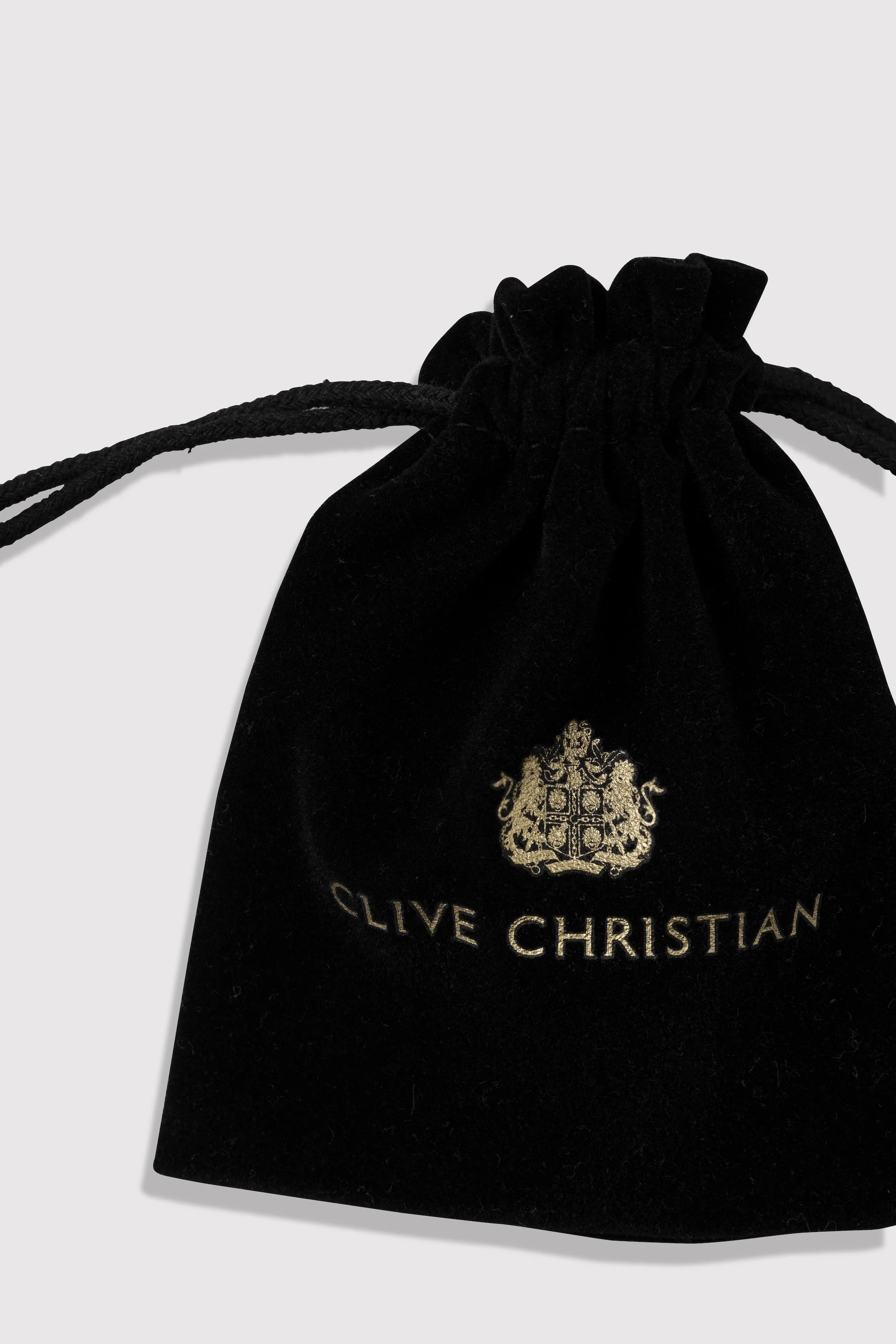 Black velvet gift bag with gold crest emblem and the words "Live Christian" embroidered, with black drawstring cords.