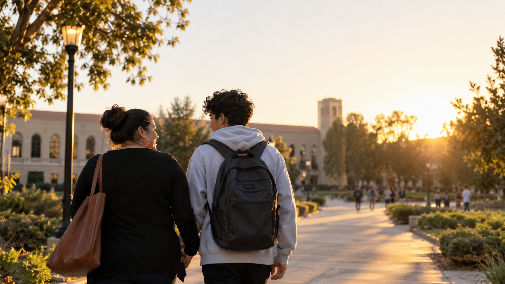 A parent and high school student walking together toward a college campus at sunset, representing the La Fuerza de Uno Scholarship.