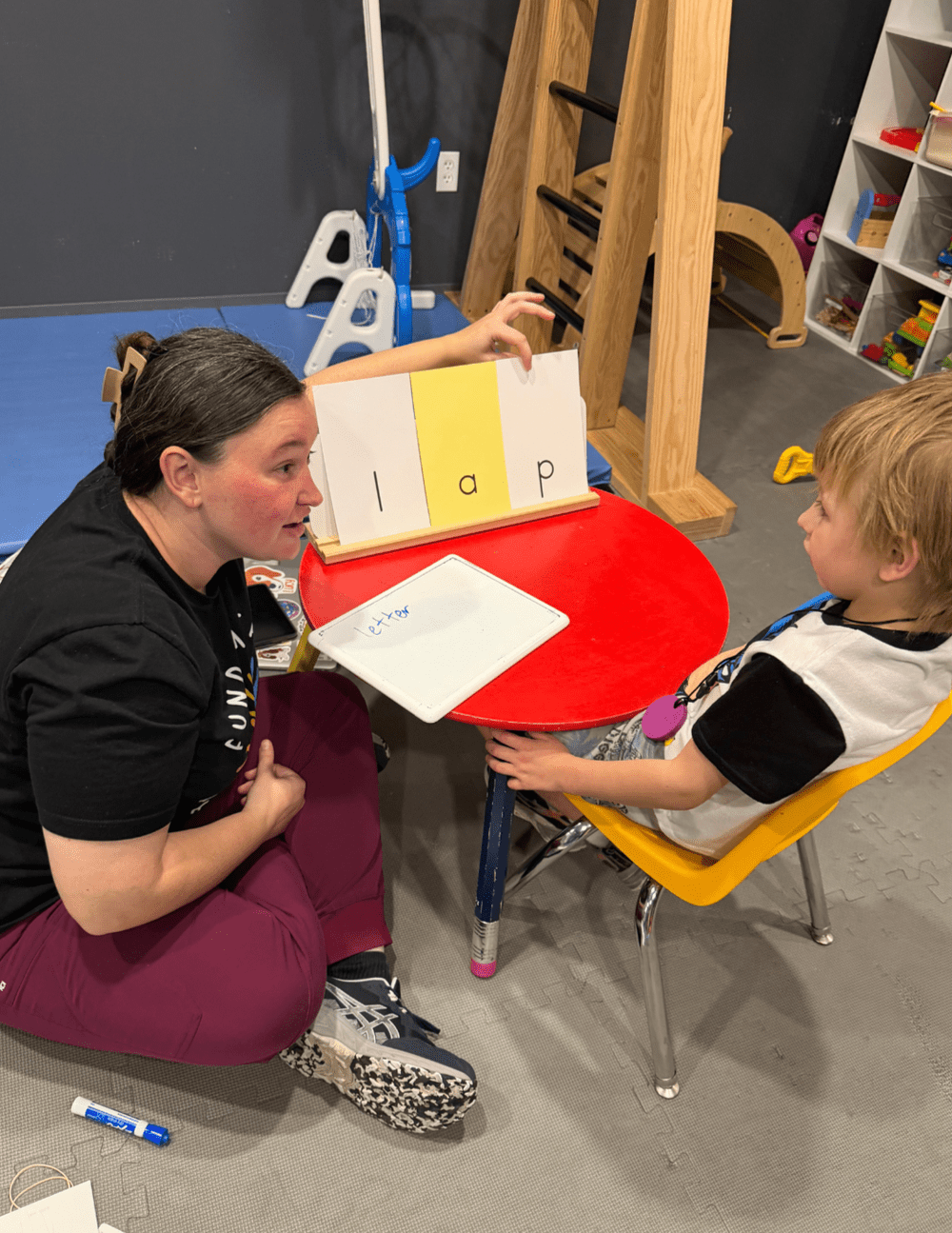 A speech-language pathologist working on reading with a child