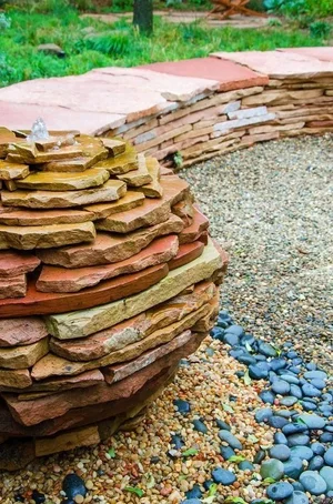 Dry-stacked stone pillar beside a gravel path