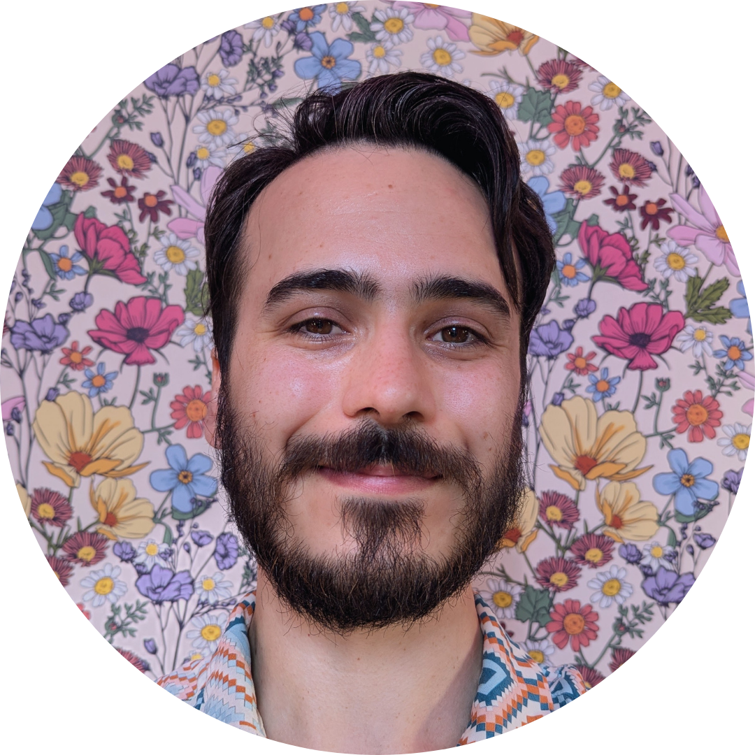 Close-up of Thomas Mudge standing in front of a colorful floral background.