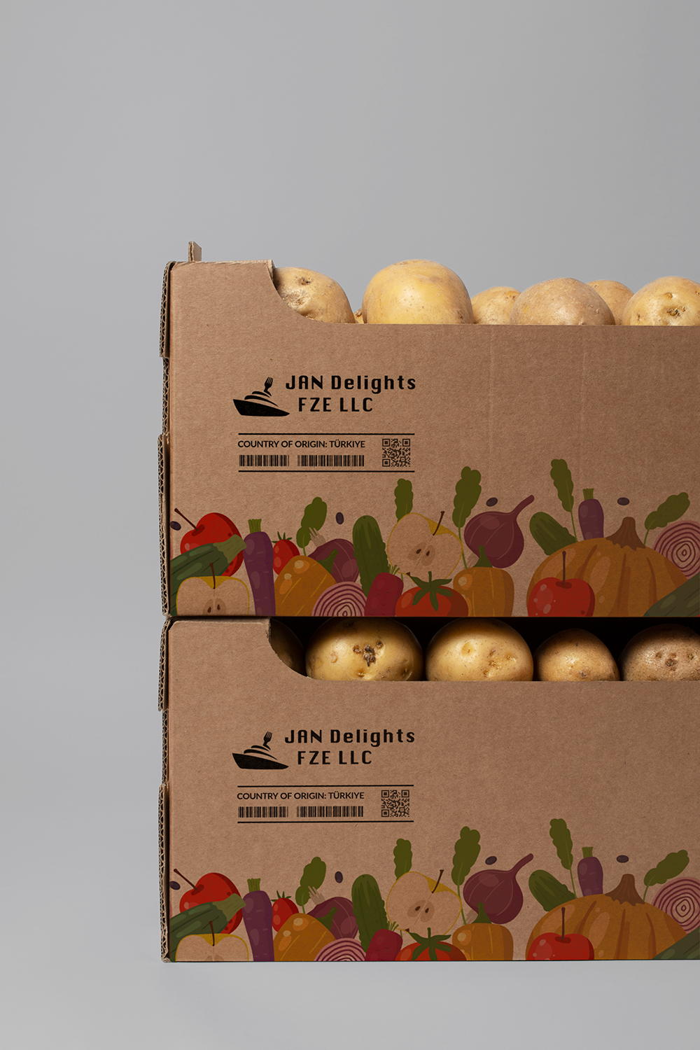 Stacked cardboard boxes with colorful vegetable illustrations, containing potatoes, with a plain gray background.