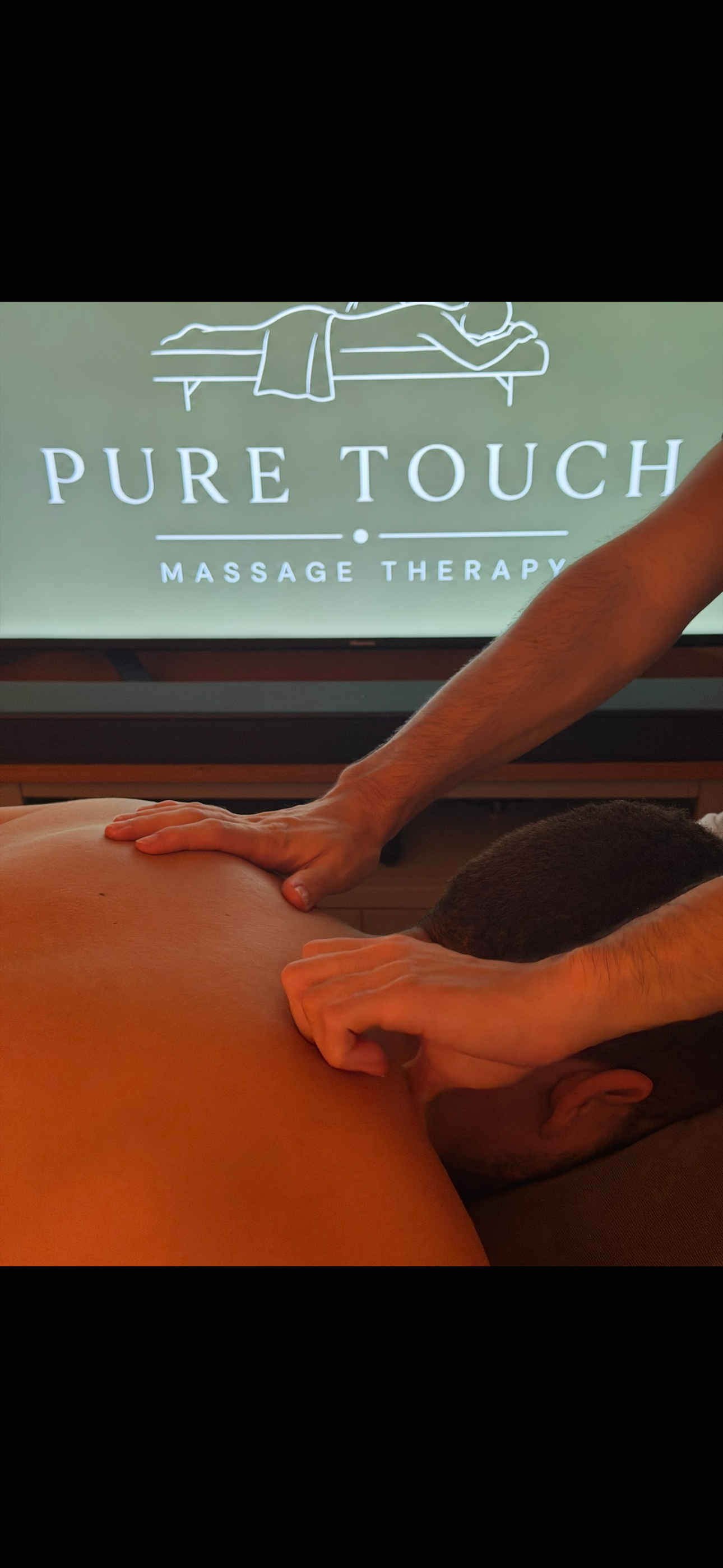 Massage therapist applying pressure to a client's back during a massage at Pure Touch Massage Therapy.
