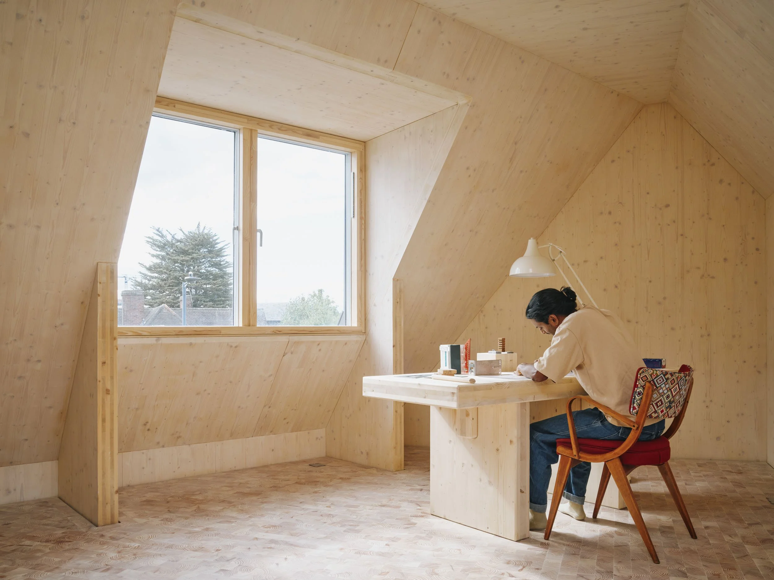 Sebastian Ferrão of 538 Works at his desk in the CLT attic room of Wood House