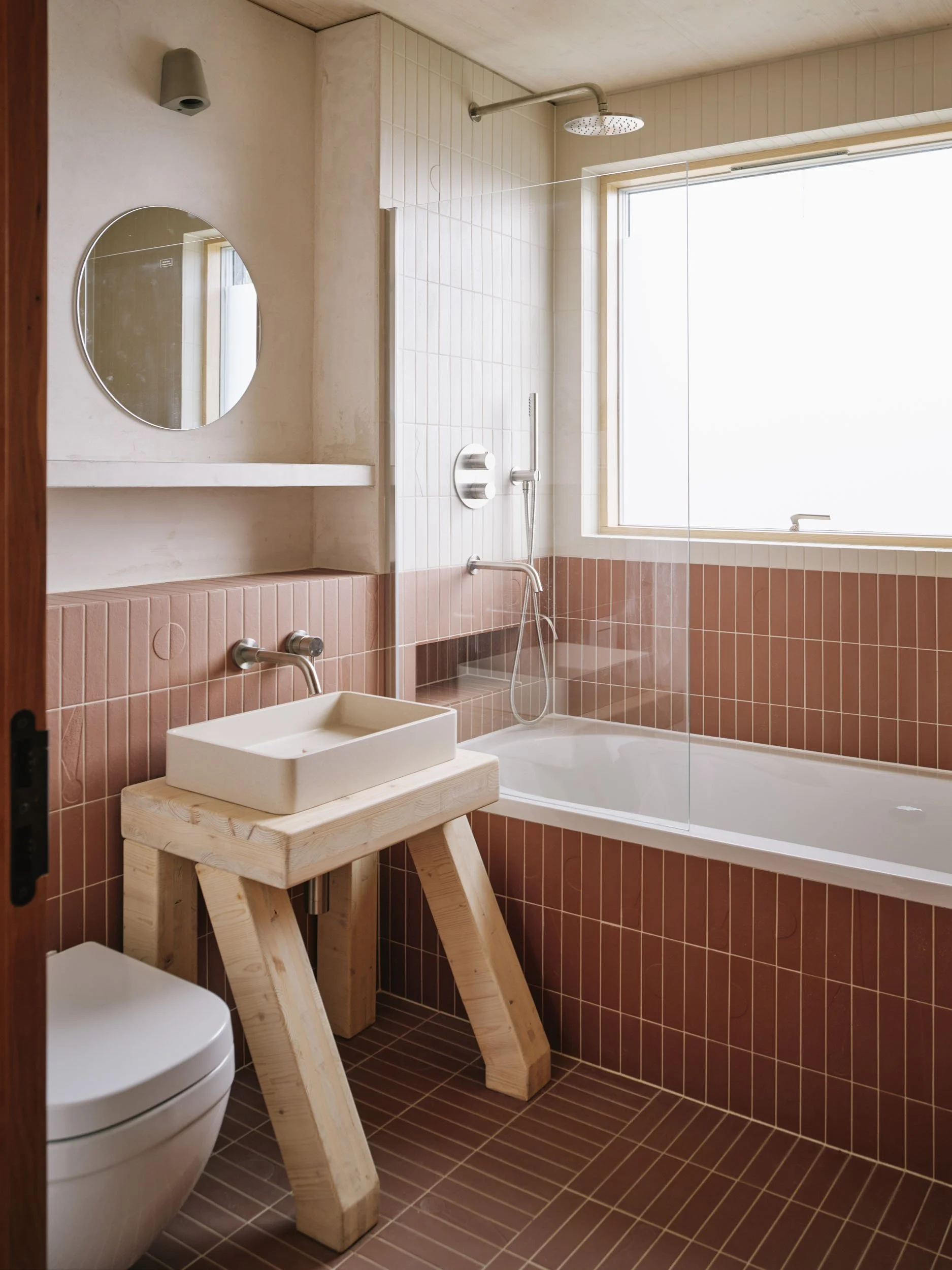 Bathroom with red tiles and a timber washstand