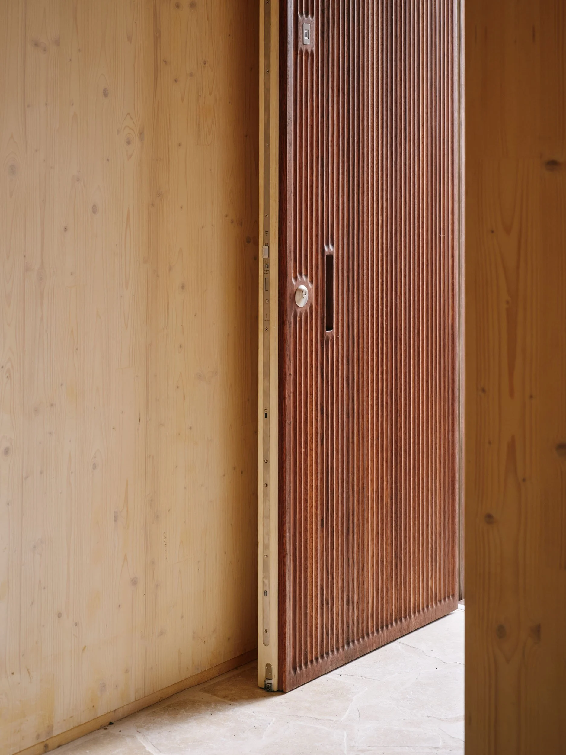Dark timber door set into a CLT wall