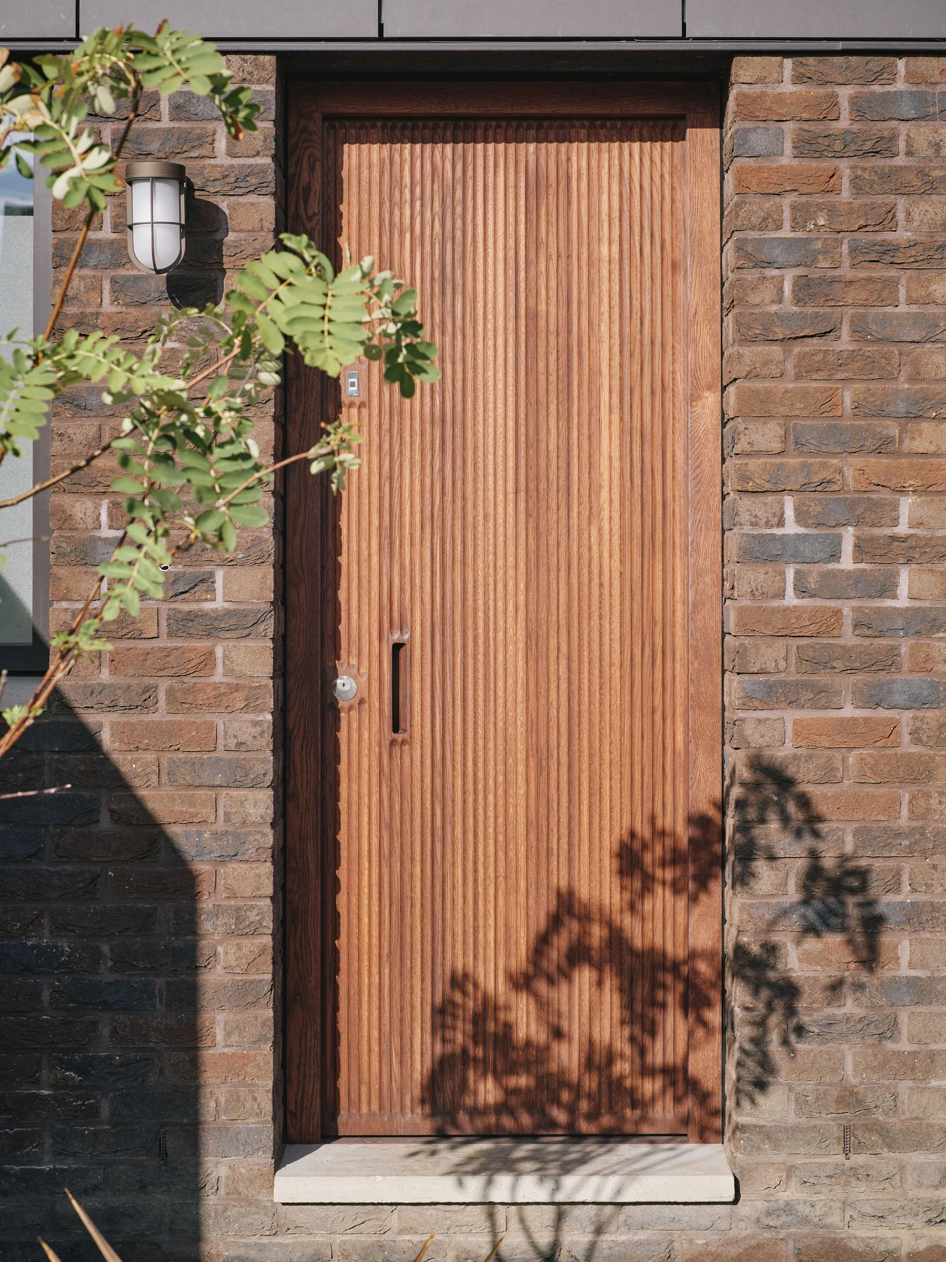 Timber front door of Wood House set in brick
