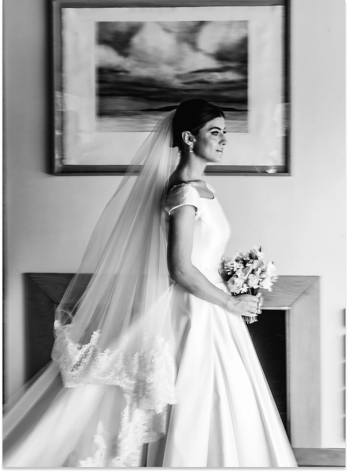 Femme en robe de mariée avec un bouquet de fleurs, portant un voile, en intérieur.