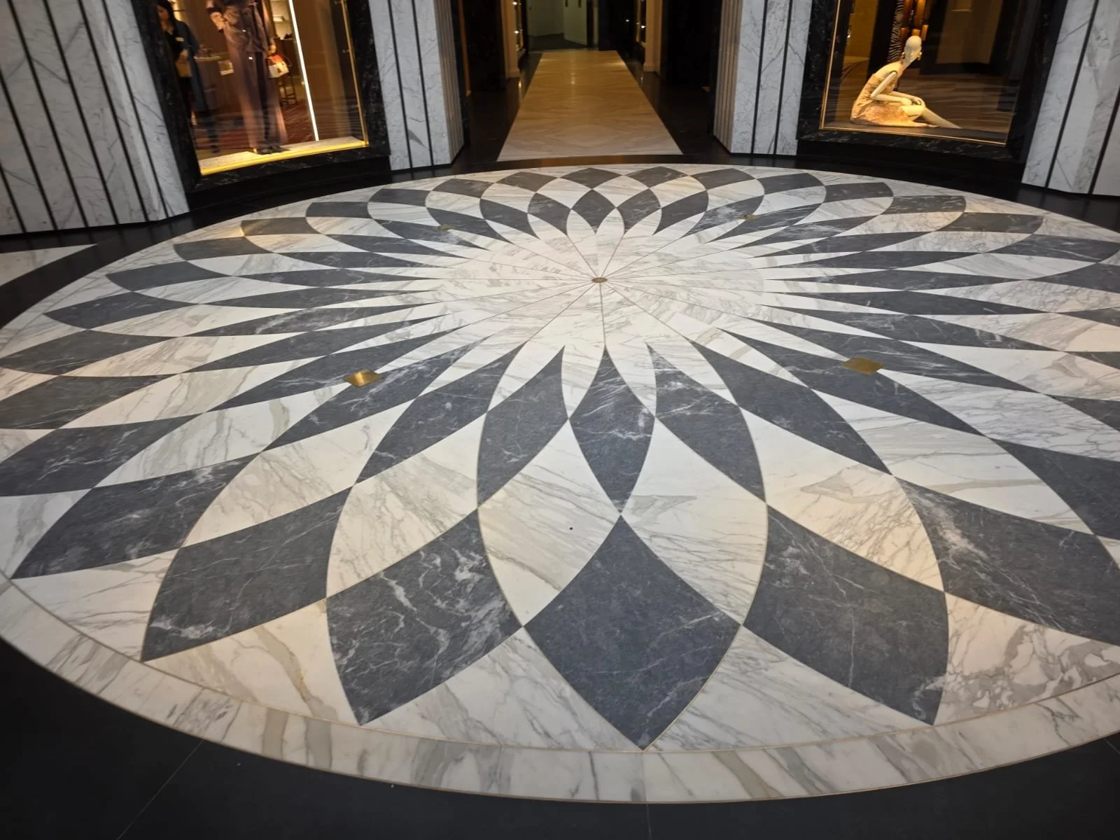 Large black-and-white marble compass rose mosaic covering the floor of an elegant interior lobby