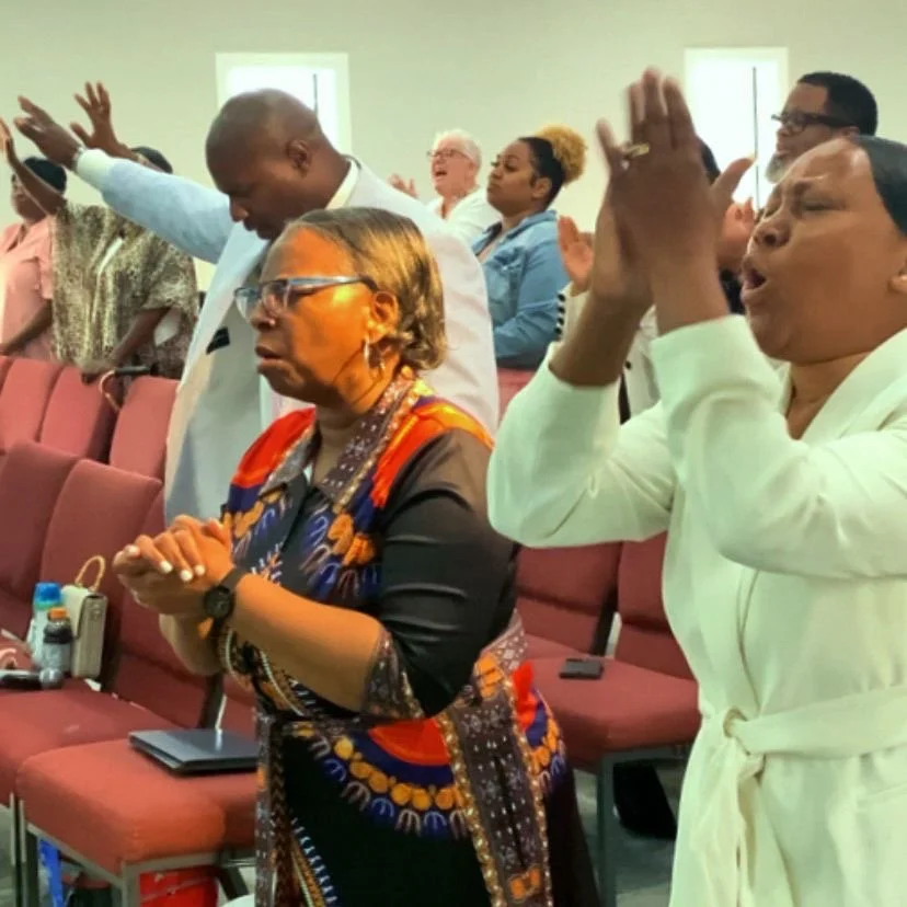 People praying and worshipping in a church setting.