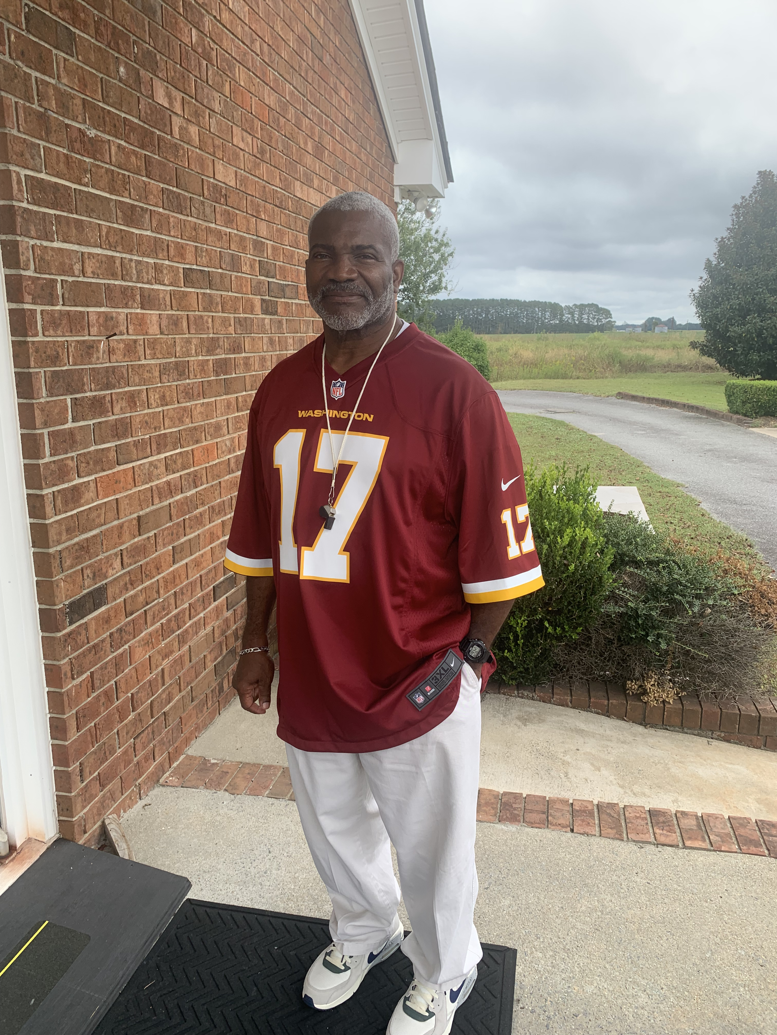 Man standing outside at Lion of Judah Community Church, wearing a Washington football team jersey, for Game Day Service.