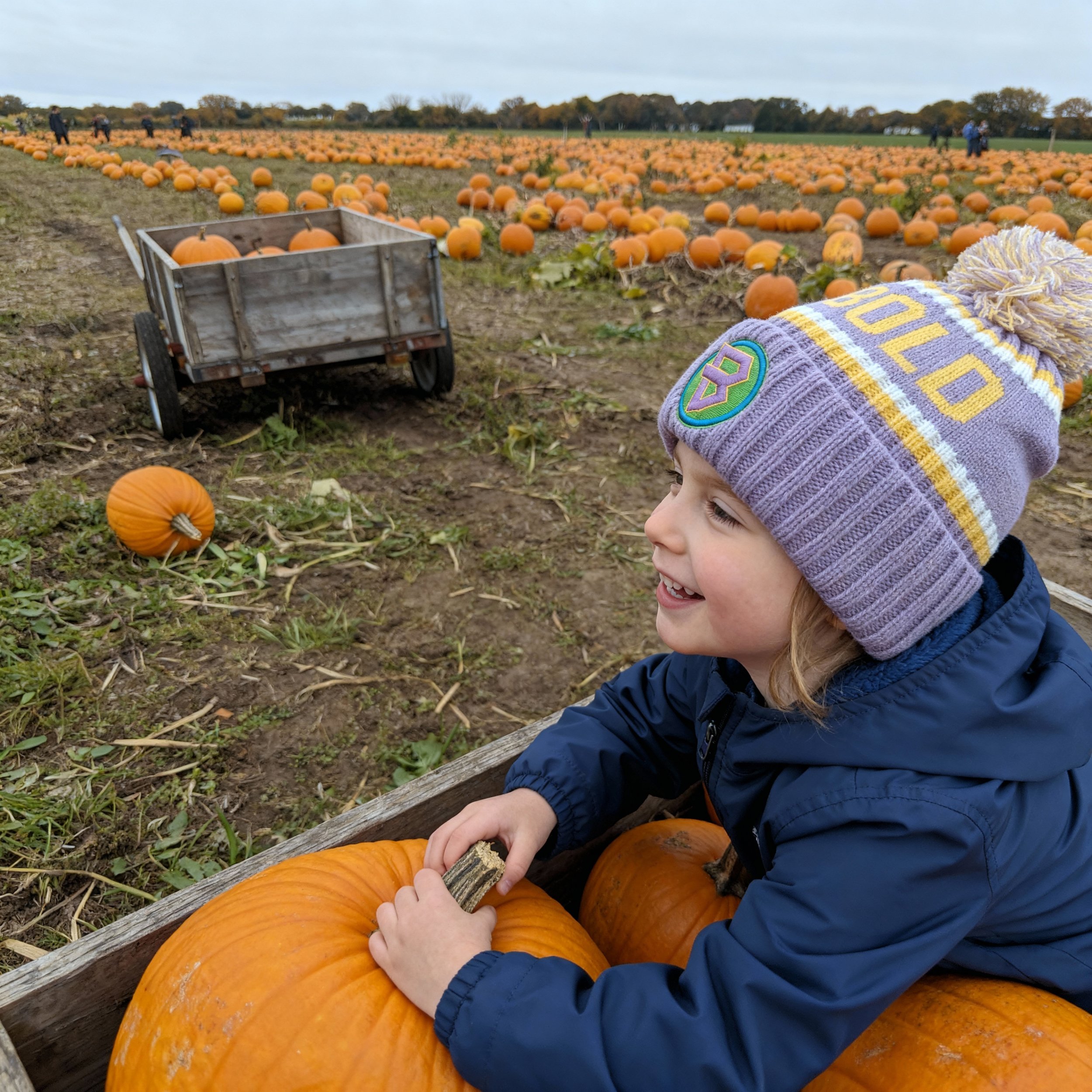 Young girl wearing bold kidswear beanie at a pumpkin field