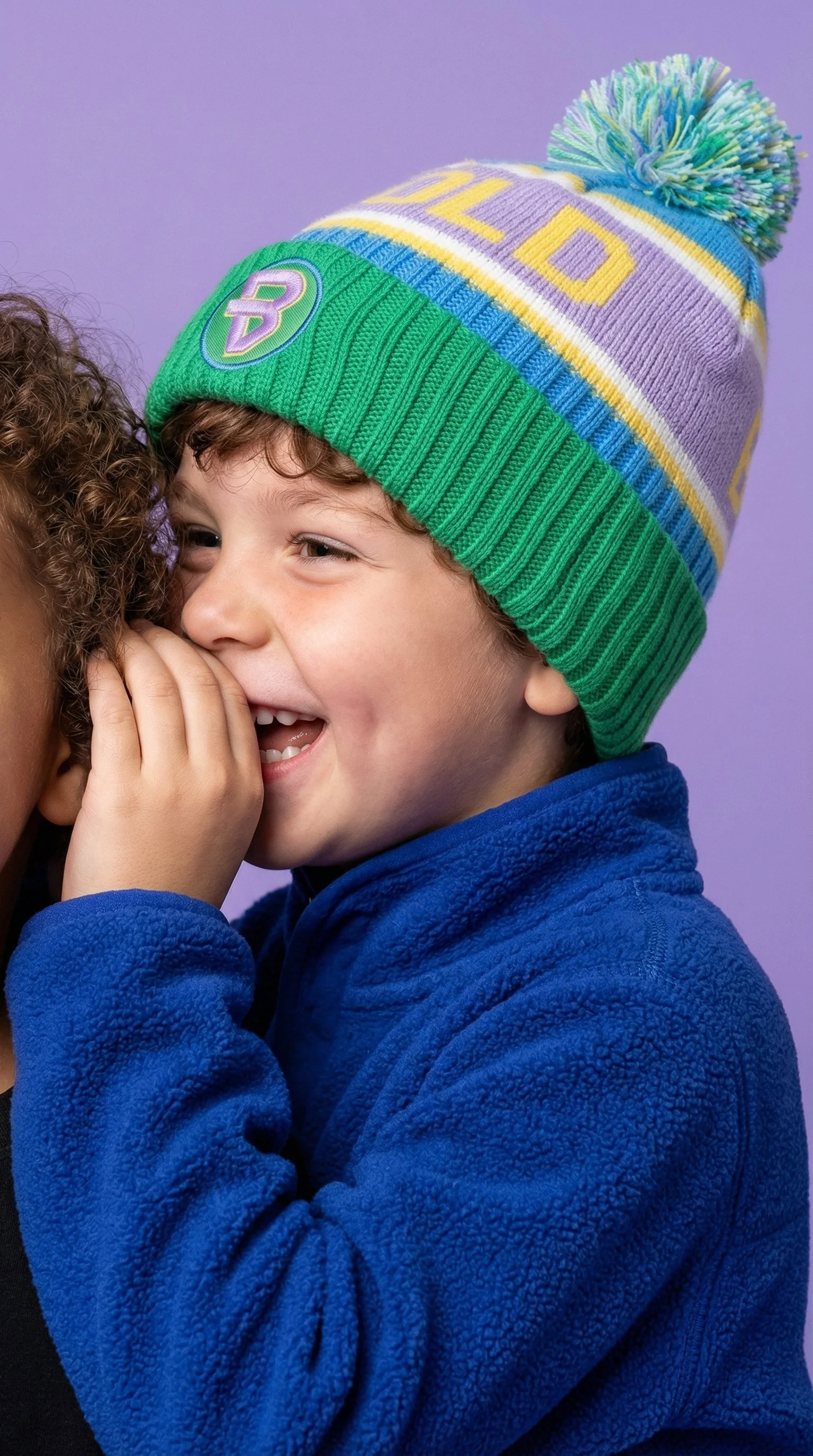 Young boy posing for studio shoot wearing bold kidswear beanie
