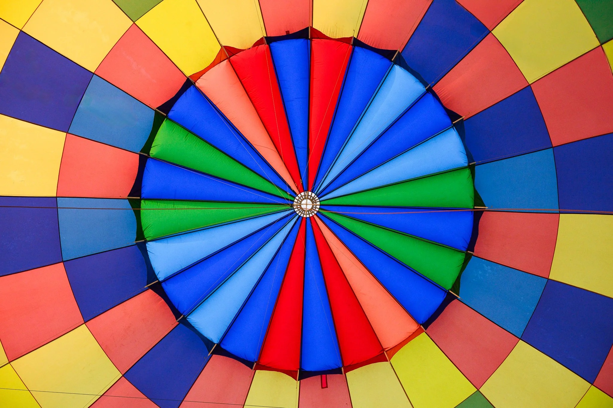 Bottom view of a colorful hot air balloon fabric with sections in yellow, red, blue, and green.