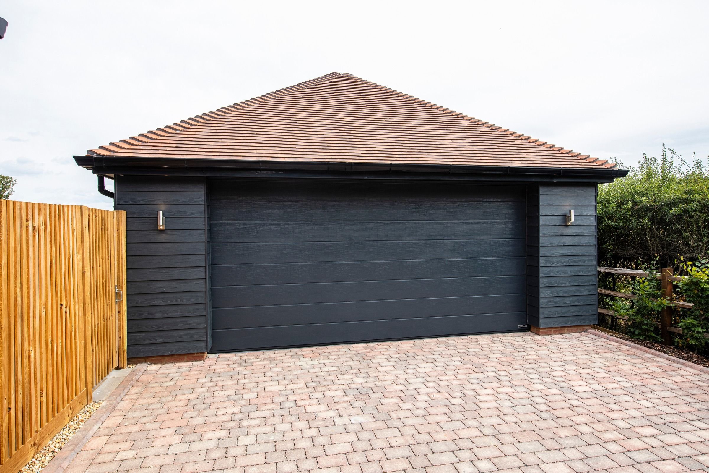 Detached double garage with a block-paved driveway.