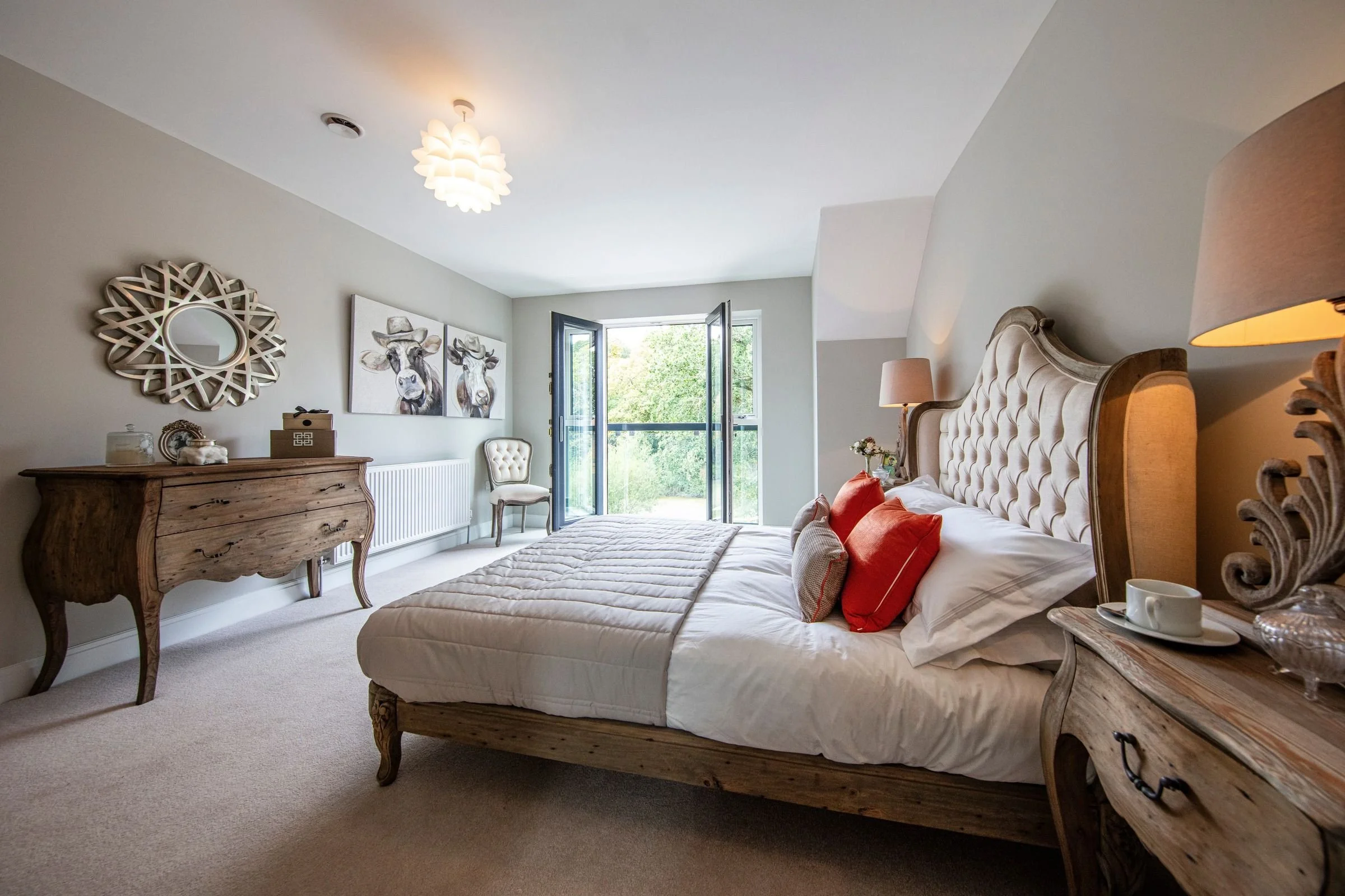 Primary bedroom with glazed doors opening to a glass Juliet balcony.