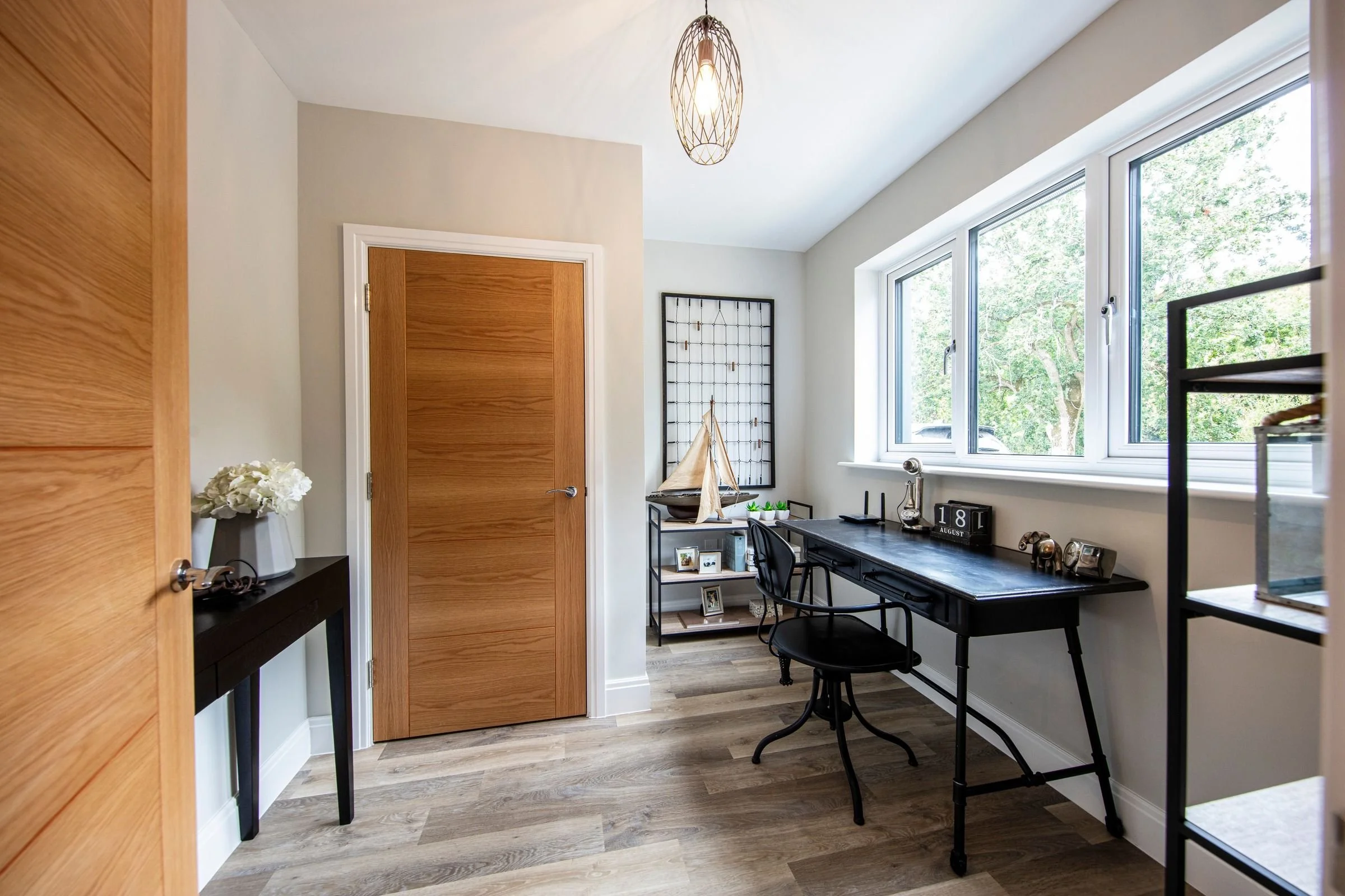 View into the study showing oak internal doors and a wide window.