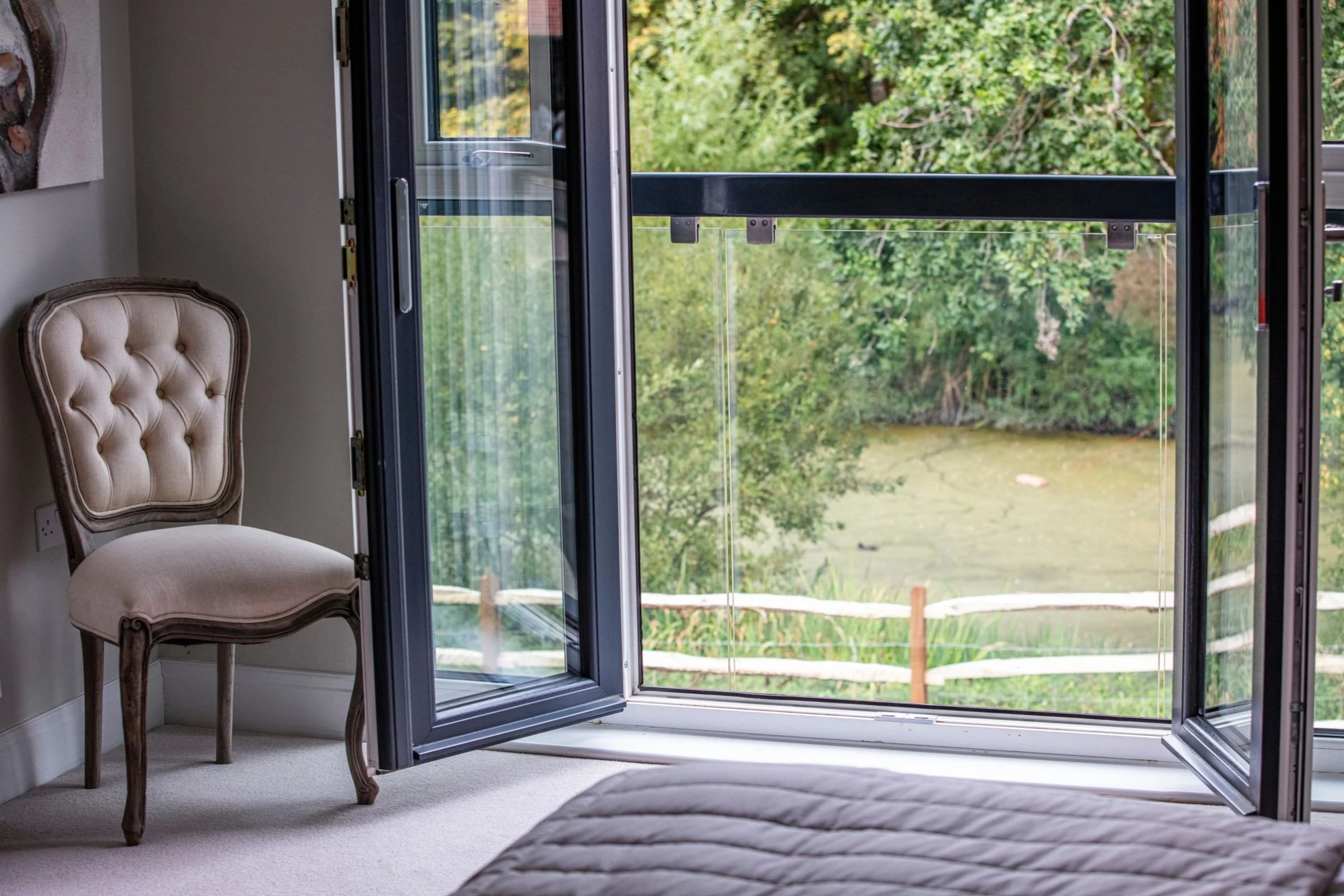 Juliet balcony overlooking the pond and mature trees.