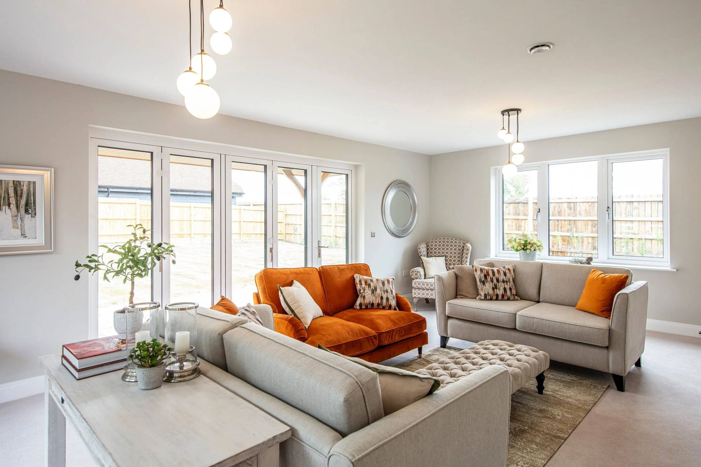 Light-filled lounge with windows and bifold doors overlooking the garden.