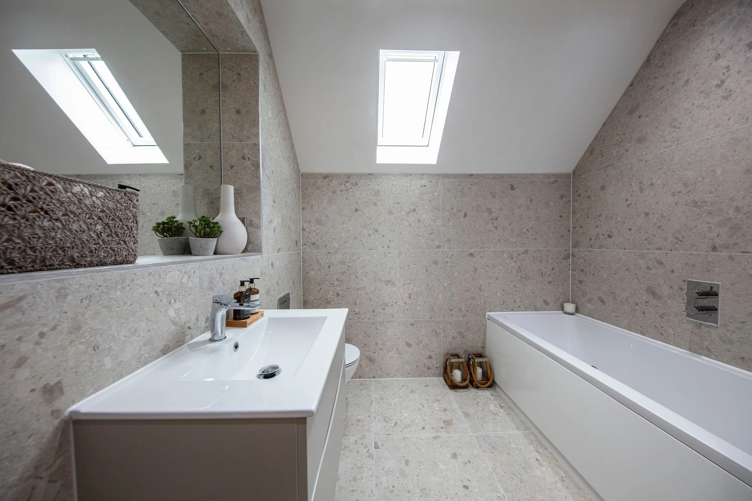 Fitted bath and wall-hung vanity beneath a rooflight in the family bathroom.