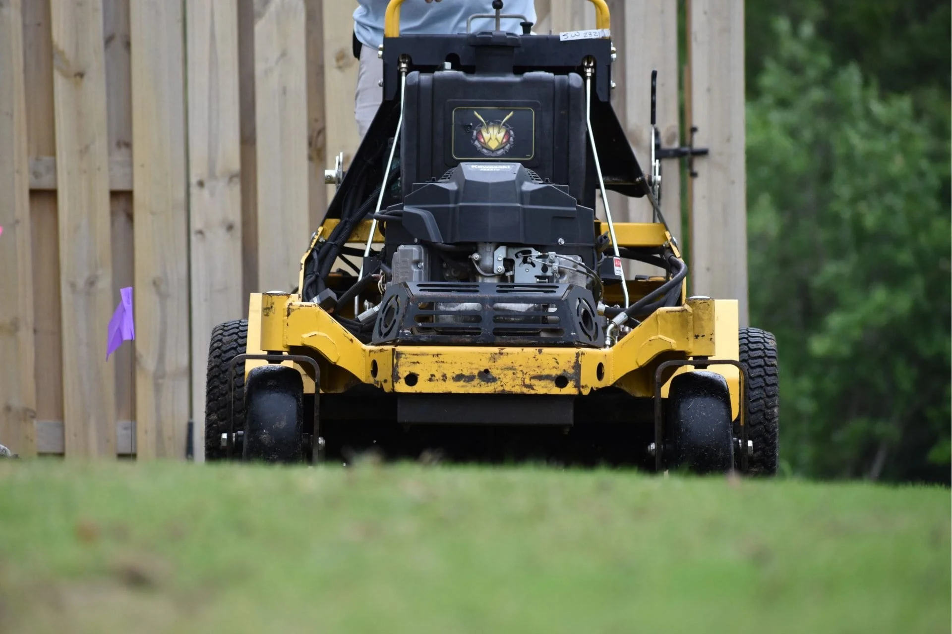 Aeration equipment parked beside a wooden fence at a residential property in Wilmington, NC