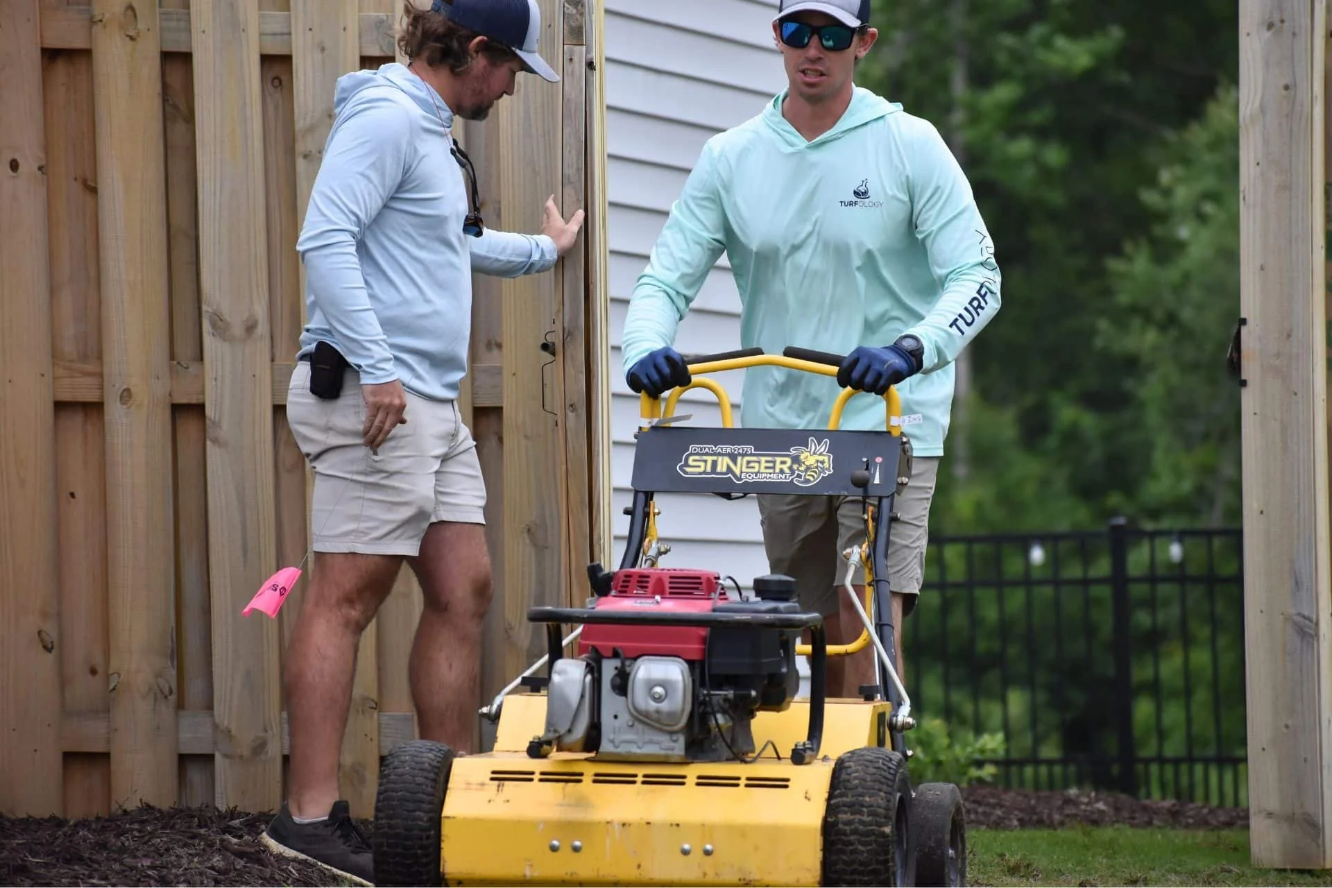 Two Turfology technicians operating aeration equipment at a residential property in Wilmington, NC