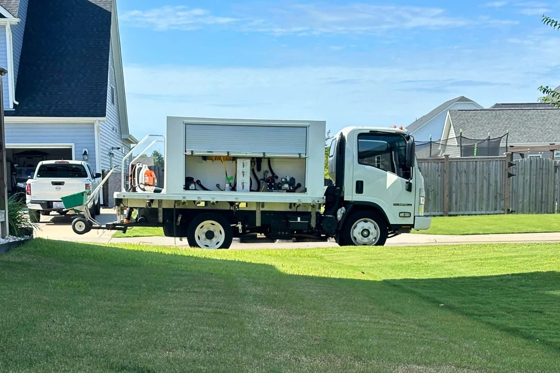 Turfology service truck equipped with lawn care application equipment parked at a residential property in Wilmington, NC