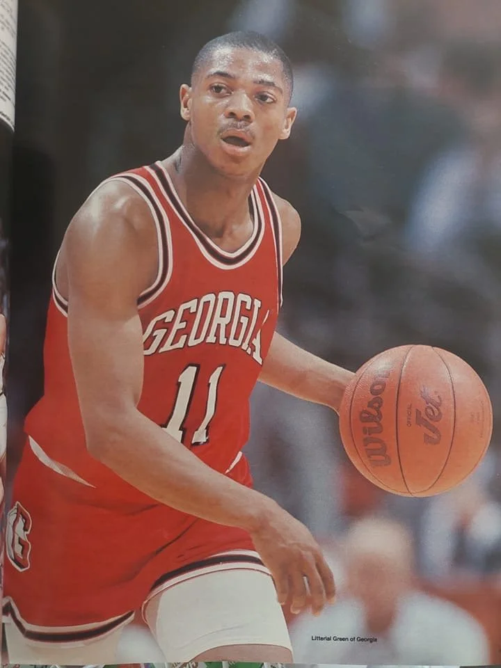 A male basketball player in a red Georgia Bulldogs uniform with the number 11, holding a Wilson basketball during a game.