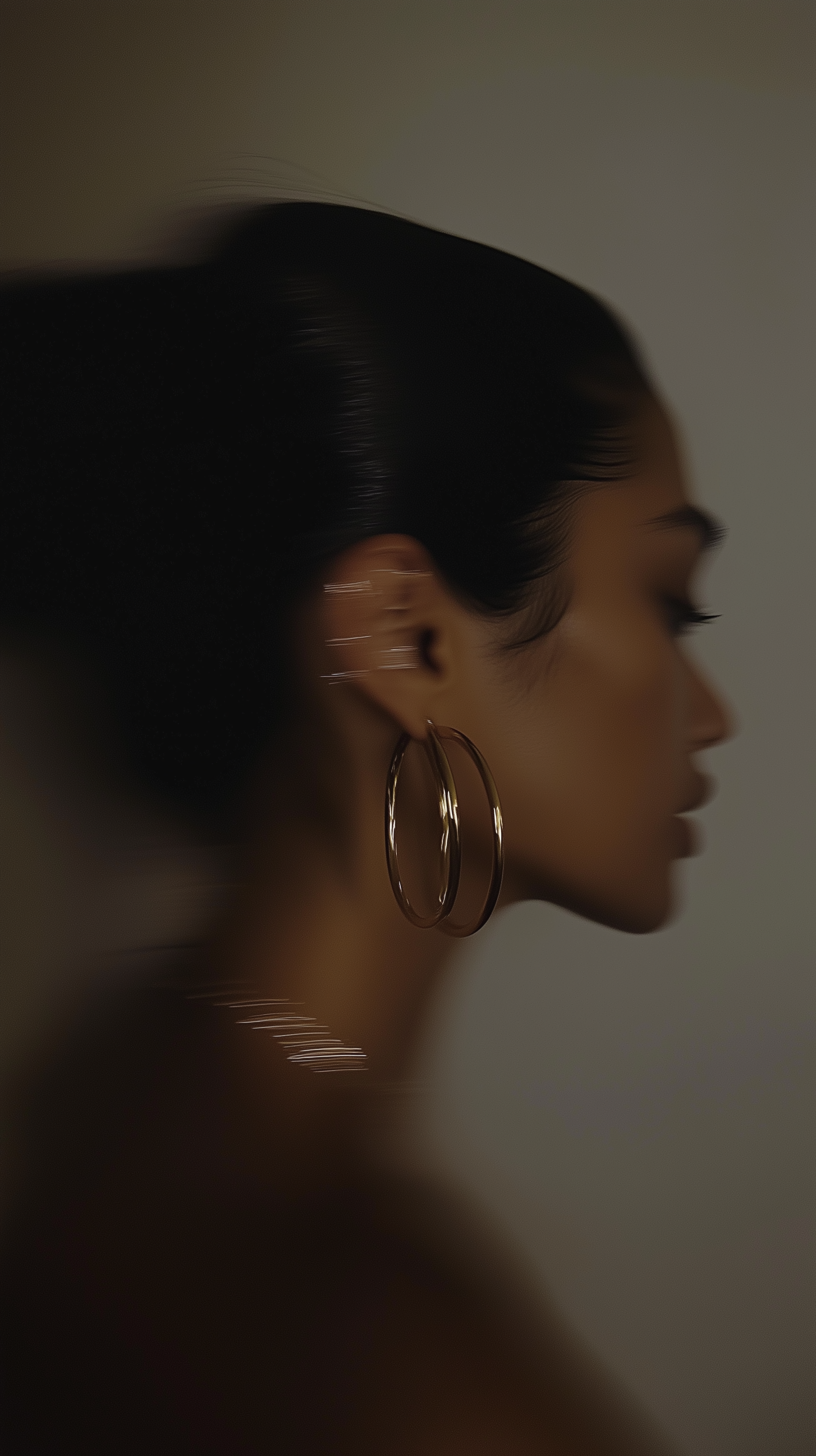 Retrato de perfil de uma mulher negra com cabelo afro, franja e grandes argolas douradas.