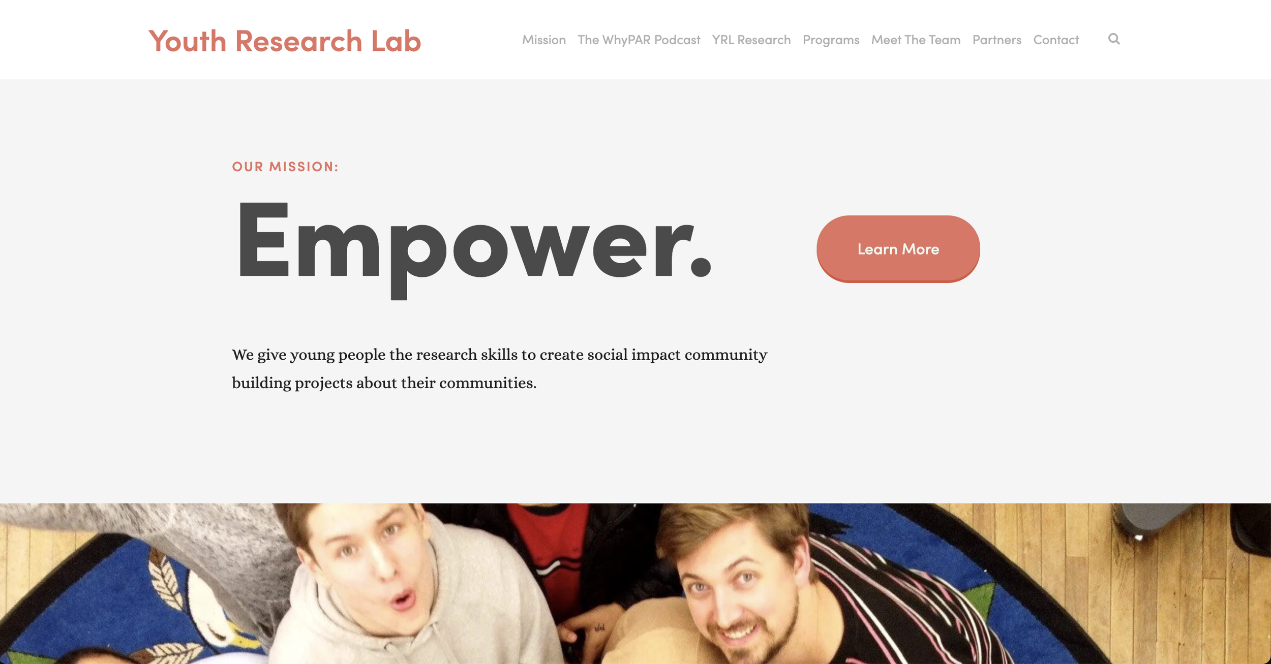 Website homepage for Youth Research Lab with a tagline 'Empower.' and a 'Learn More' button, featuring a photo of young people smiling in an indoor space.