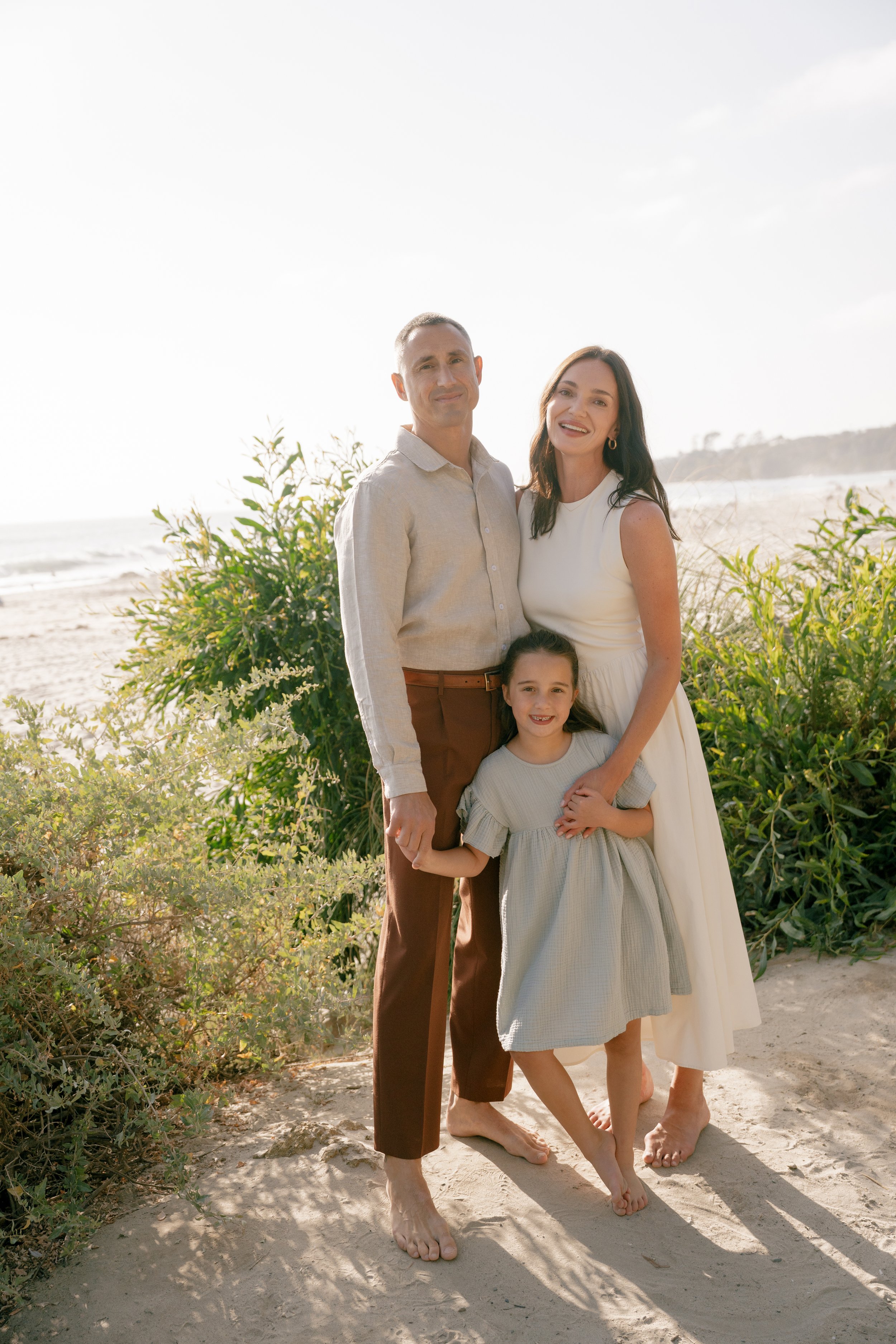 Julia, Rob and their daughter posing for a lifestyle photoshoot on the beach in Southern California. 