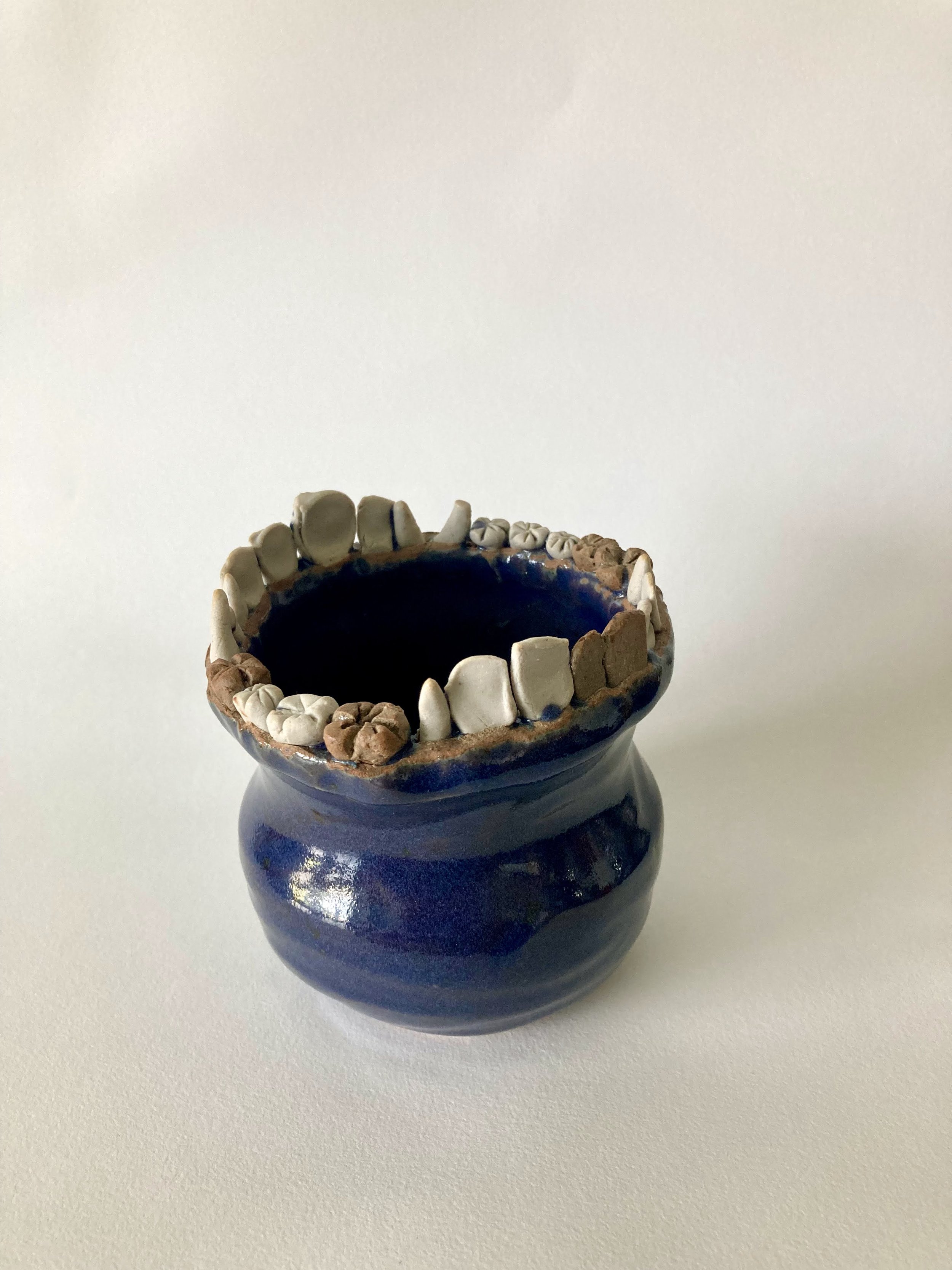 Stoneware vase with stoneware and porcelain teeth accents