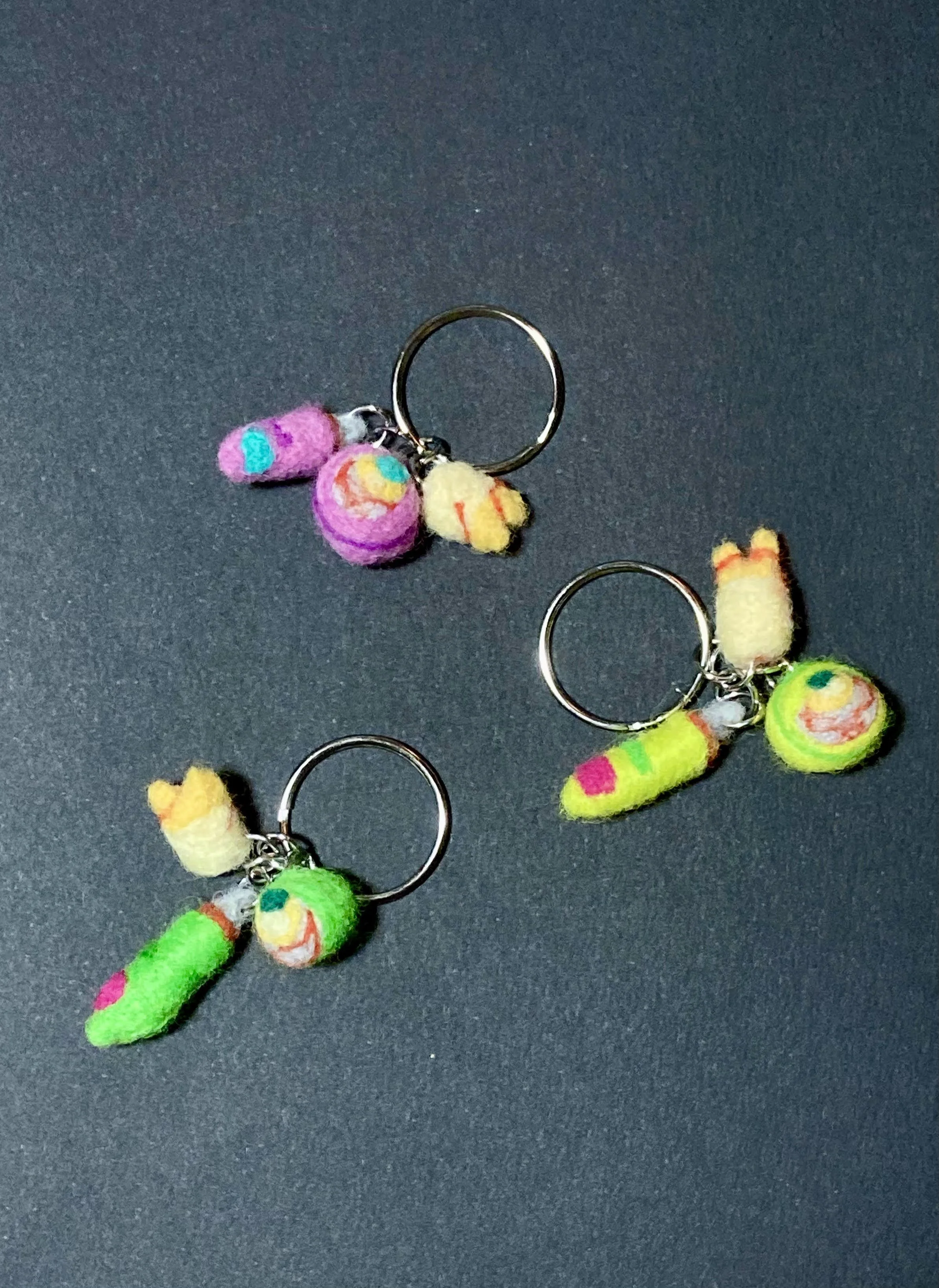 Needle felted keychains with an eye, fingertip, and tooth
