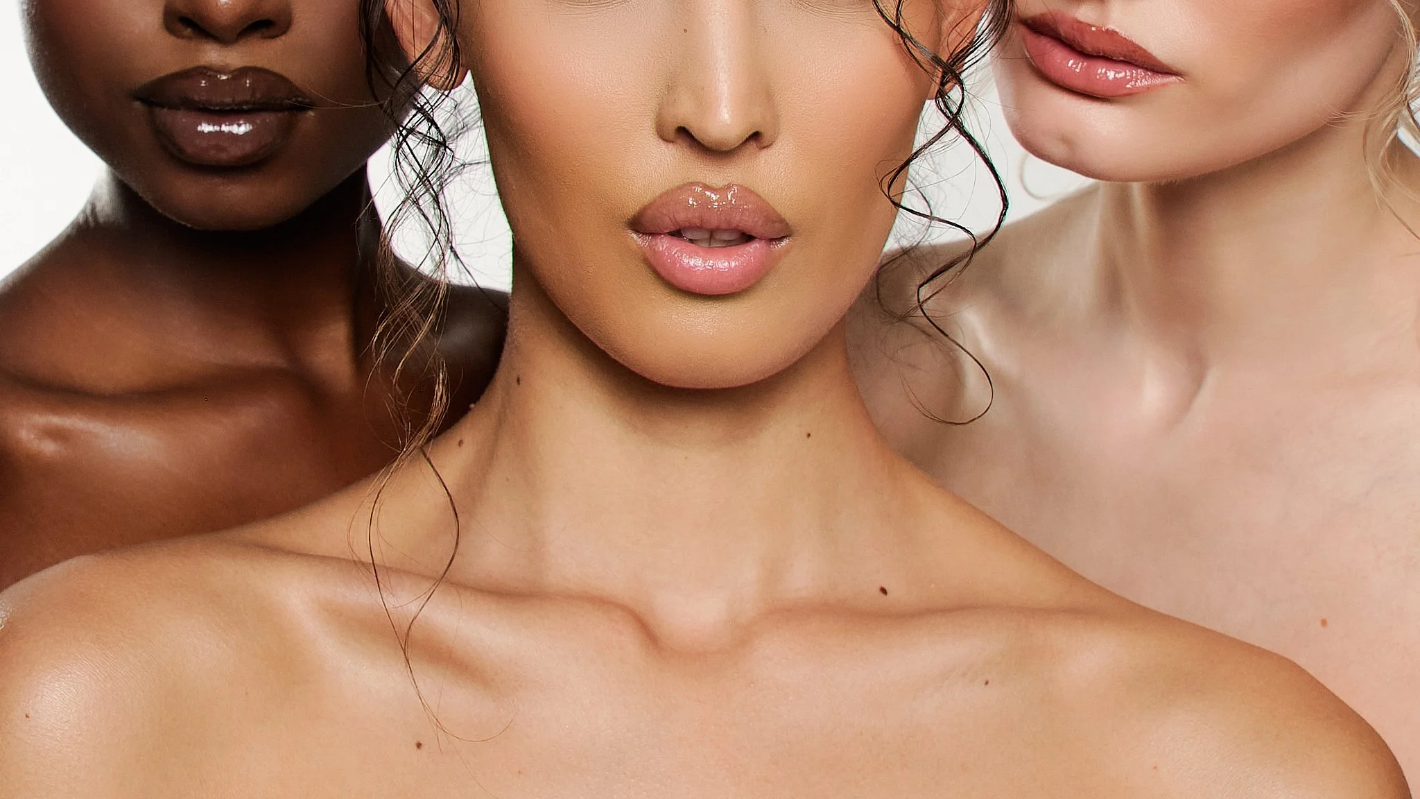 Close-up of three women with different skin tones, showing their mouths and parts of their faces, with glossy lips and natural beauty
