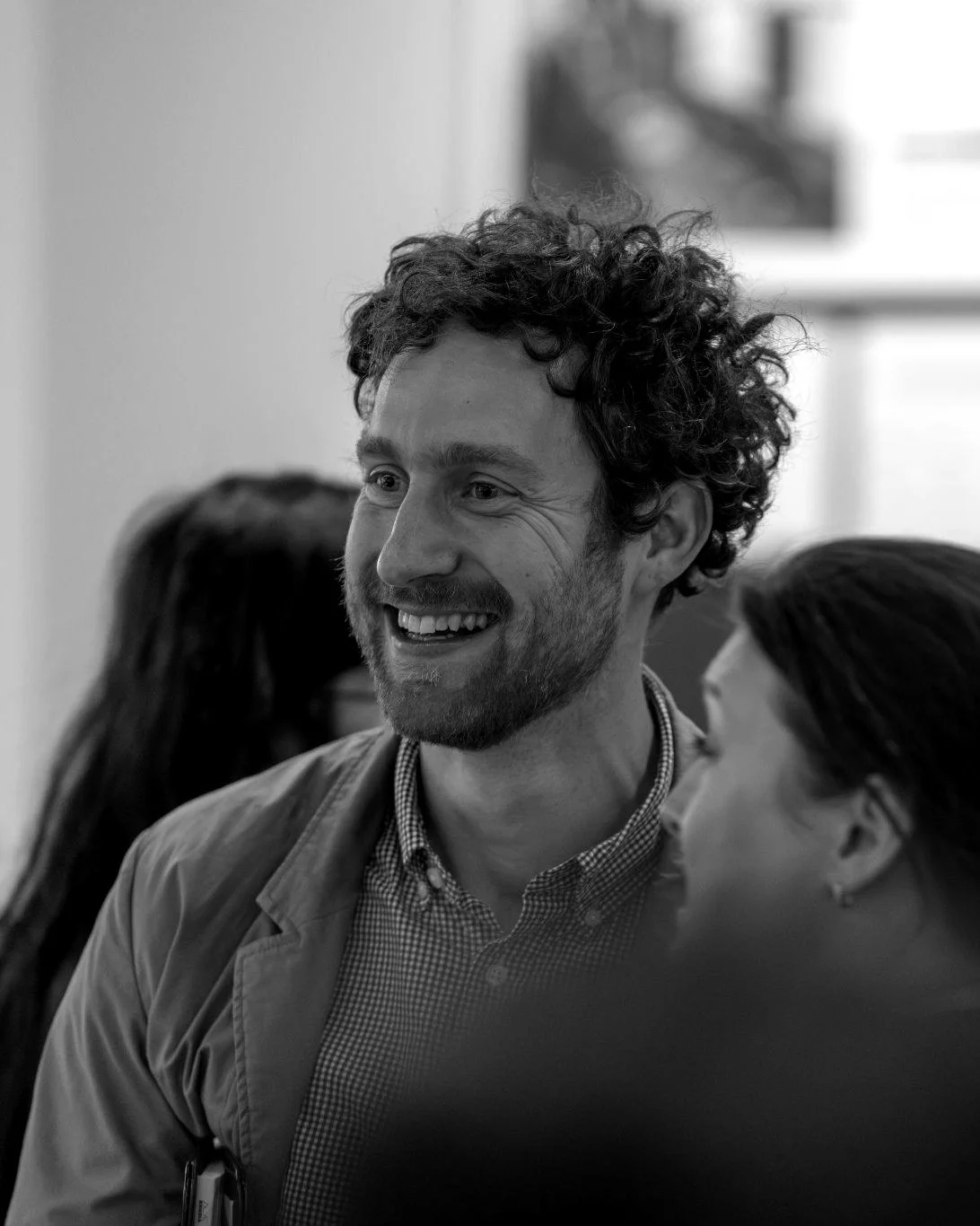Steven Deheeger smiling in conversation with a group of people