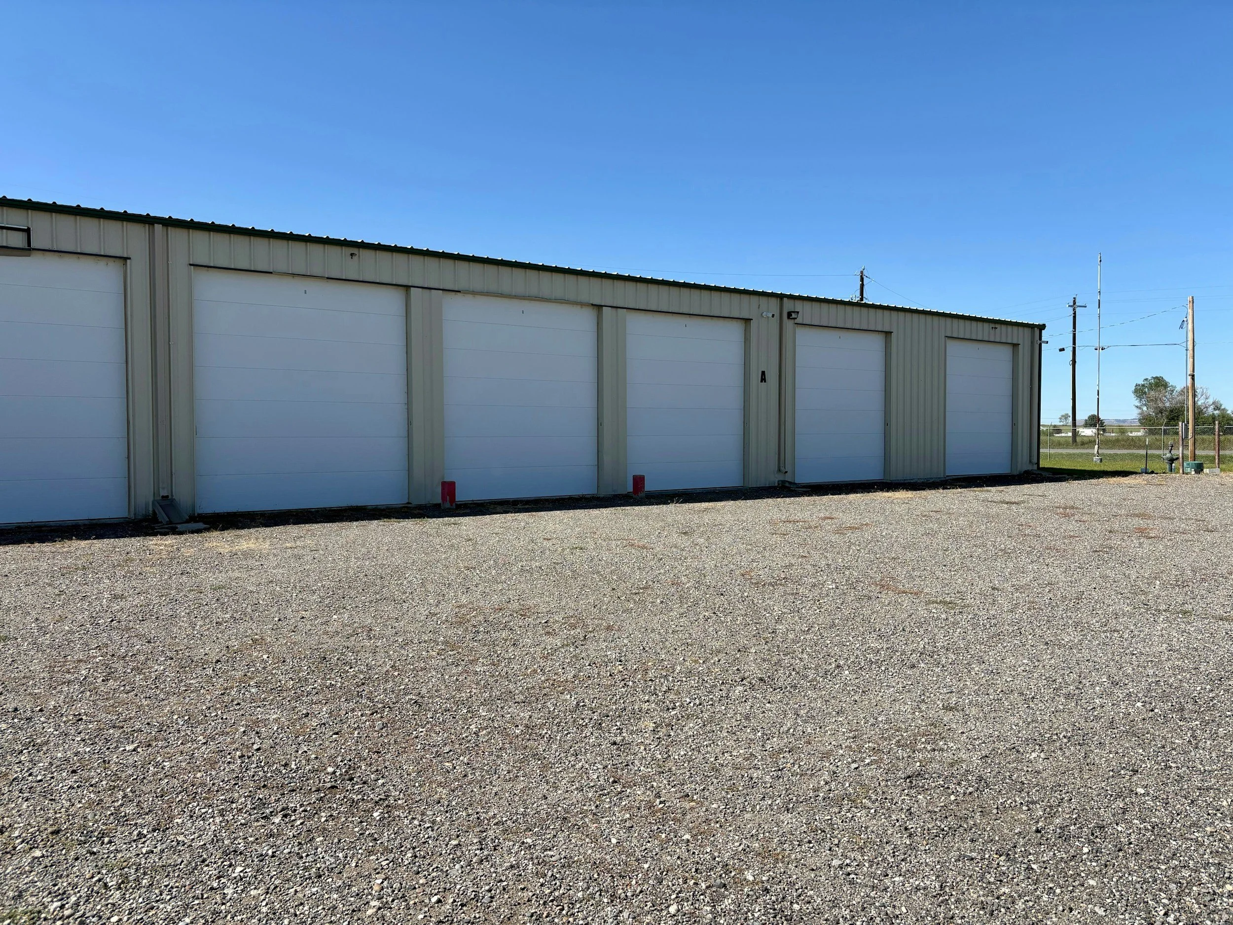 Plain single-story metal self-storage building with roll-up doors