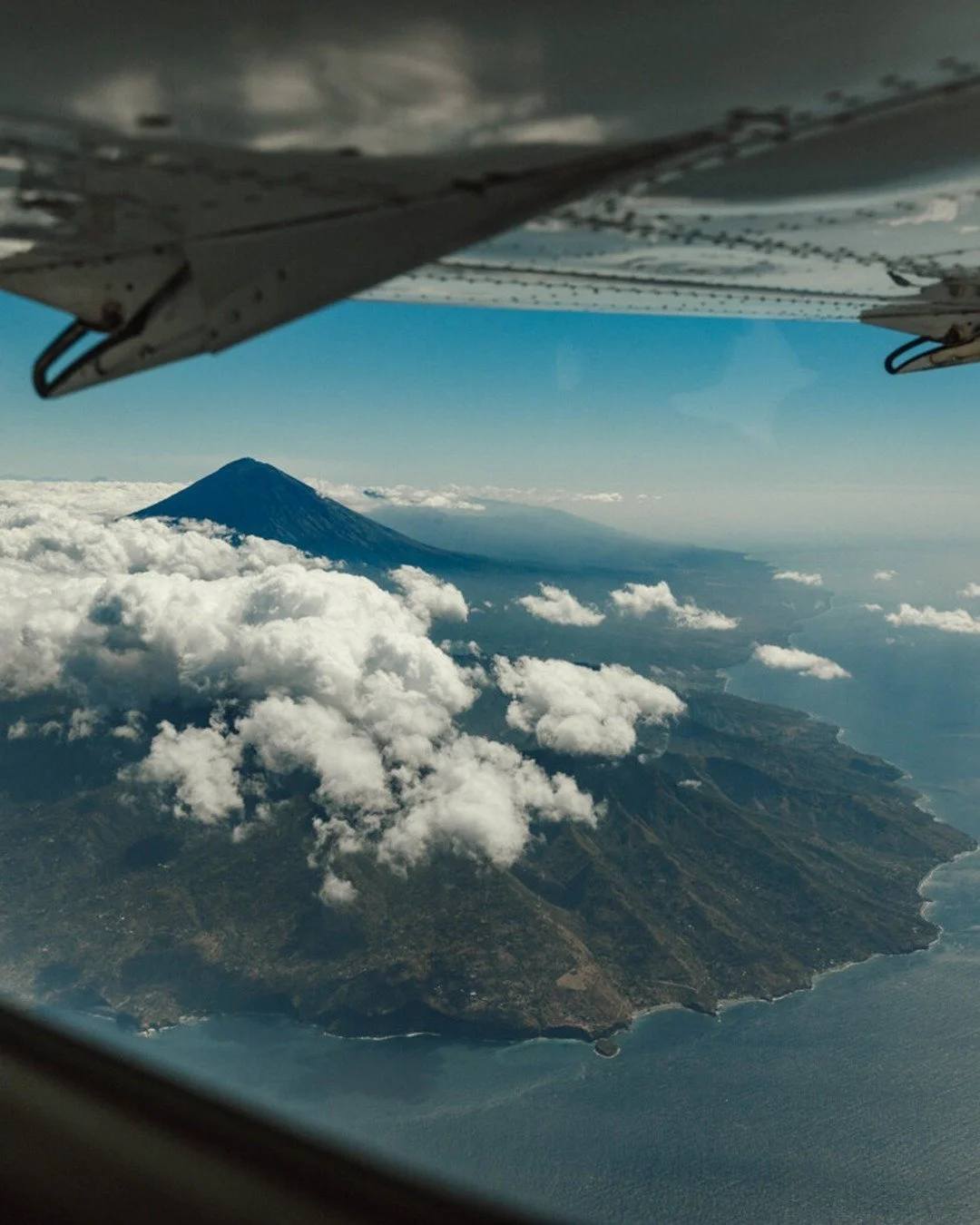View from a plane wing overlooking majestic mountains, breathtaking scenery, showcasing the beauty of travel and exploration with Bumi.