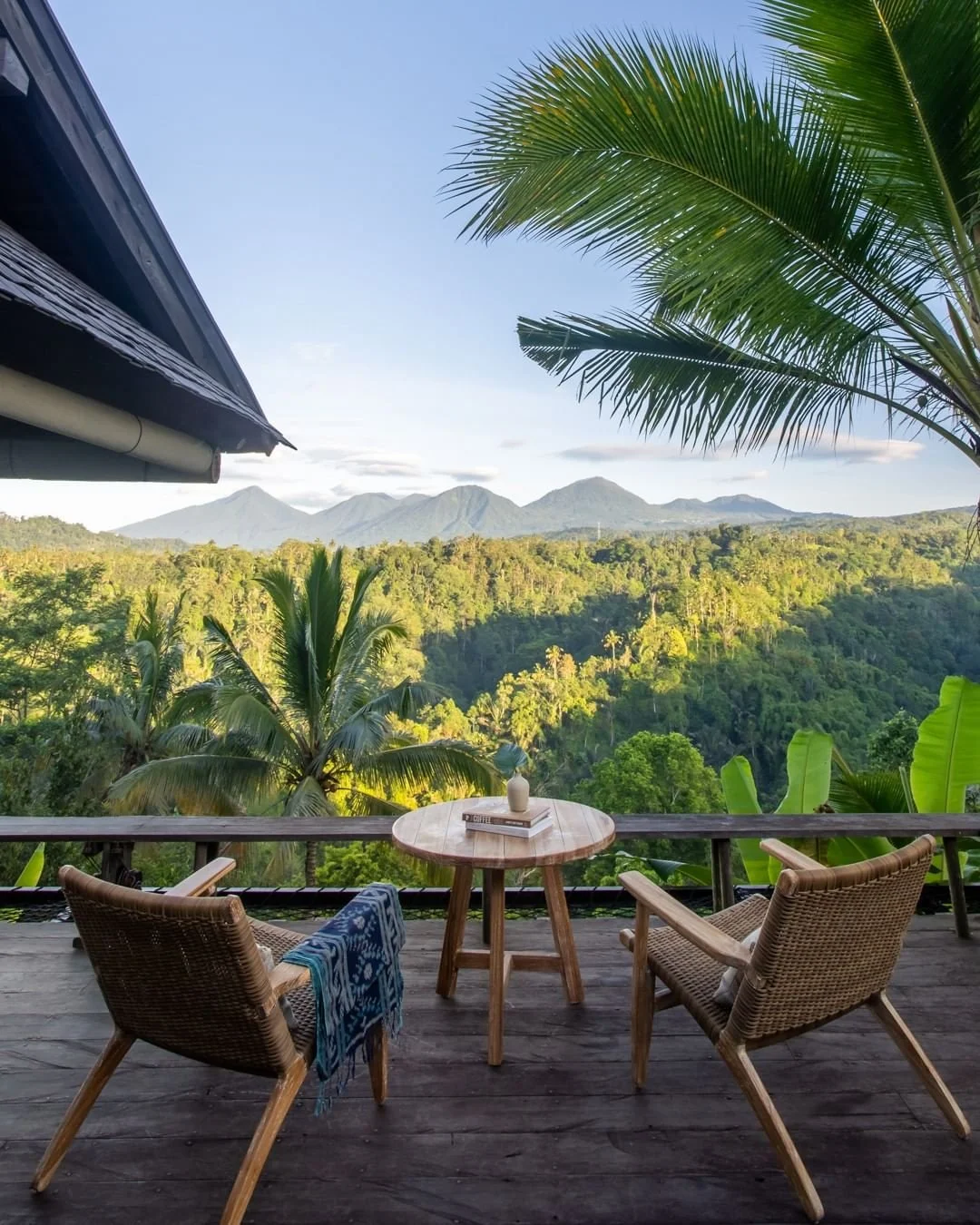 Bumi showcase a tranquil, serene view of Buahan Banyan Tree Escape in Bali, showcasing an open-air villa surrounded by dense jungle, with breathtaking mountain and river valley scenery.